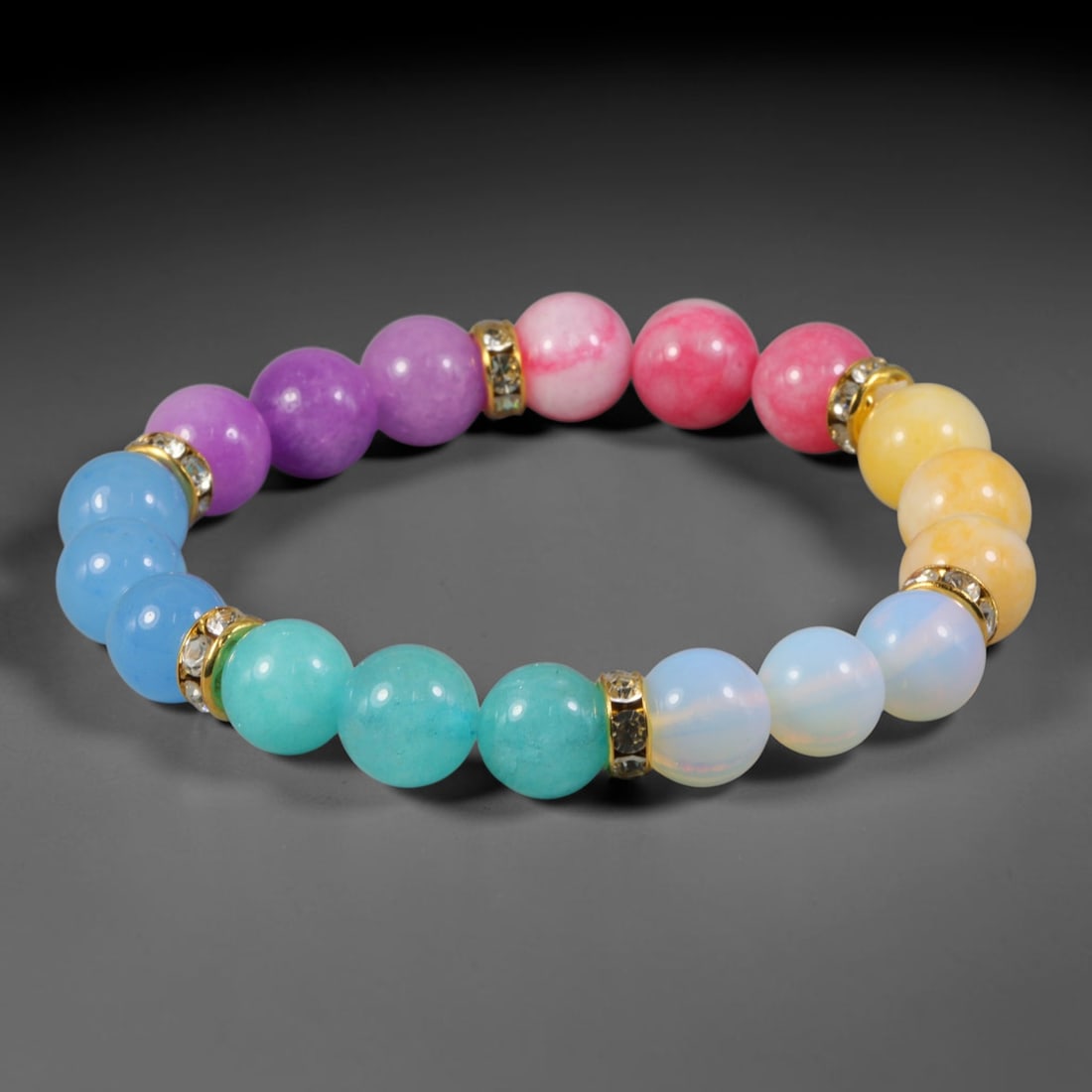 Natural Mixed Stone Beaded Bracelet - Polished Round Bead Strand, 56FA: This stretch bracelet is constructed from uniformly spherical polished natural hard stone beads paired with gold-toned metal spacers set with clear crystalline accents. The mineral beads display varie
