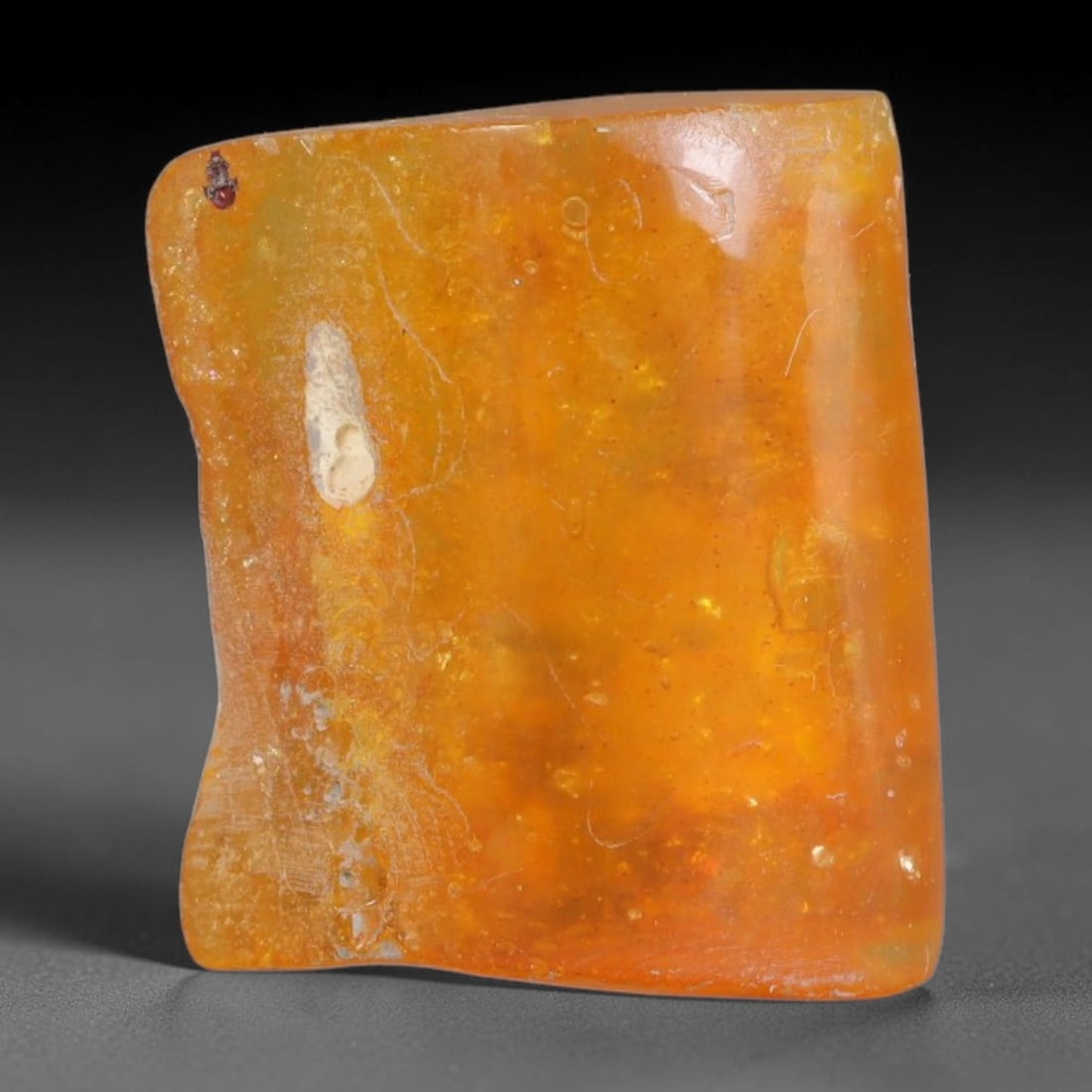 17.58ct Natural Baltic Polished Loose Freeform Amber Gemstone, 33AT: This smoothly polished freeform amber piece carries warm translucent organic clarity with fine natural fossil flecks and tiny mineral inclusions suspended throughout its 24x21mm flowing unstructured s
