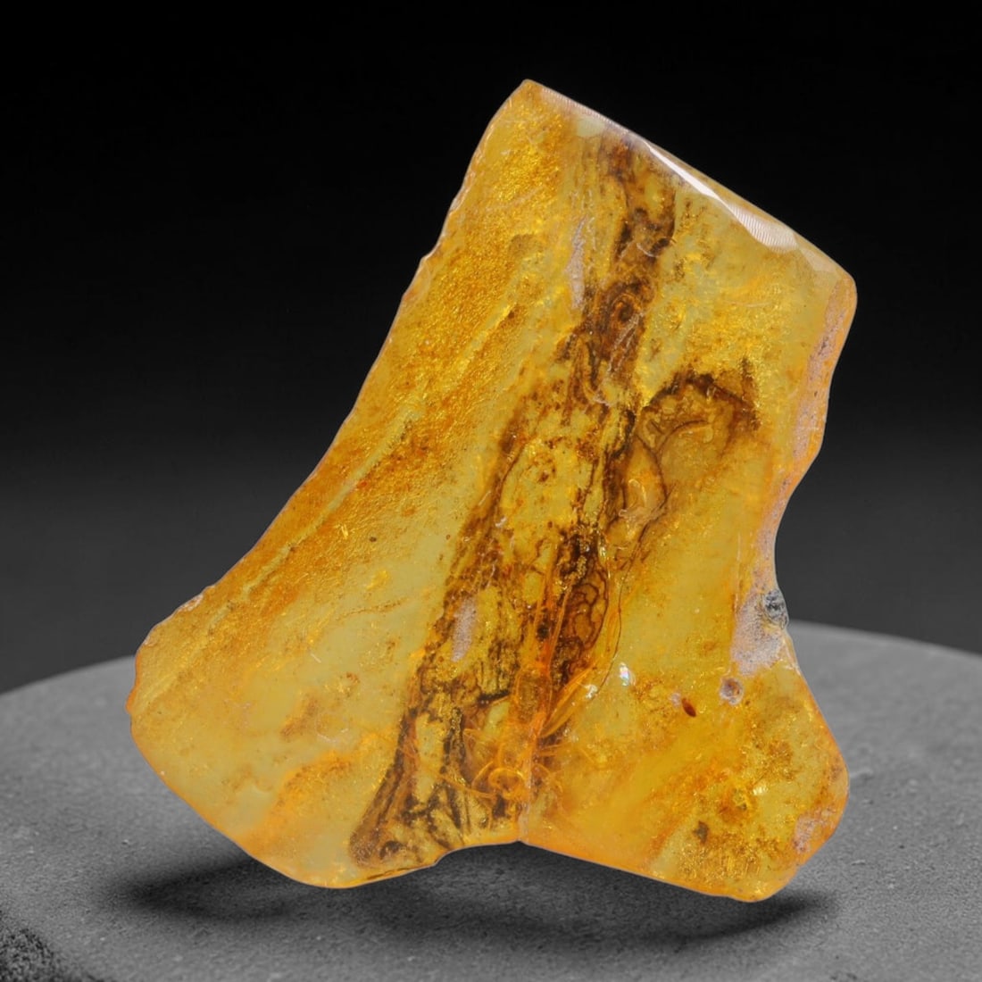 11.25ct Natural Baltic Polished Loose Freeform Amber Gemstone, 63AT: This smoothly polished freeform amber piece carries warm translucent organic clarity with fine natural fossil flecks and tiny mineral inclusions suspended throughout its 31x25mm flowing unstructured s
