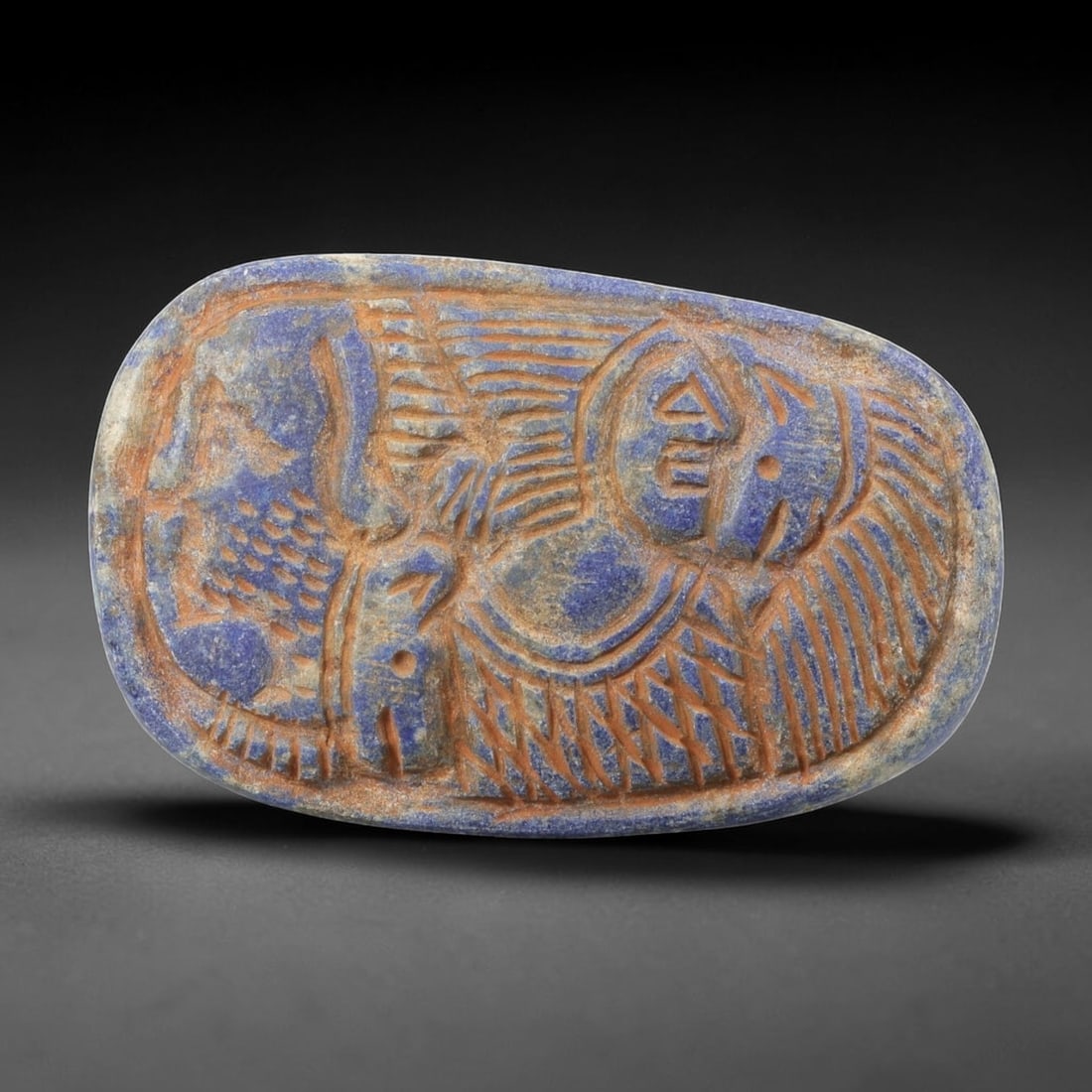 Near Eastern Lapis Lazuli Plaque - Tribal Figure & Animal Relief Carving, 95BF: Carved from rich lapis lazuli, this oval plaque features a 7x4.5cm (2.76x1.77in) relief composition centered on a stylized tribal figure, with incised linear details defining its form and geometric ac