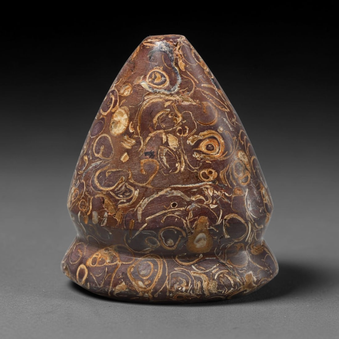 Ancient Medieval Mamluk Fossil Stone Talisman Ornament (1250-1517 CE), 62ED: This antique unperforated fossil stone talisman ornament originates from the Mamluk cultural sphere, created as a powerful protective decorative amulet. The conical form showcases striking natural tex