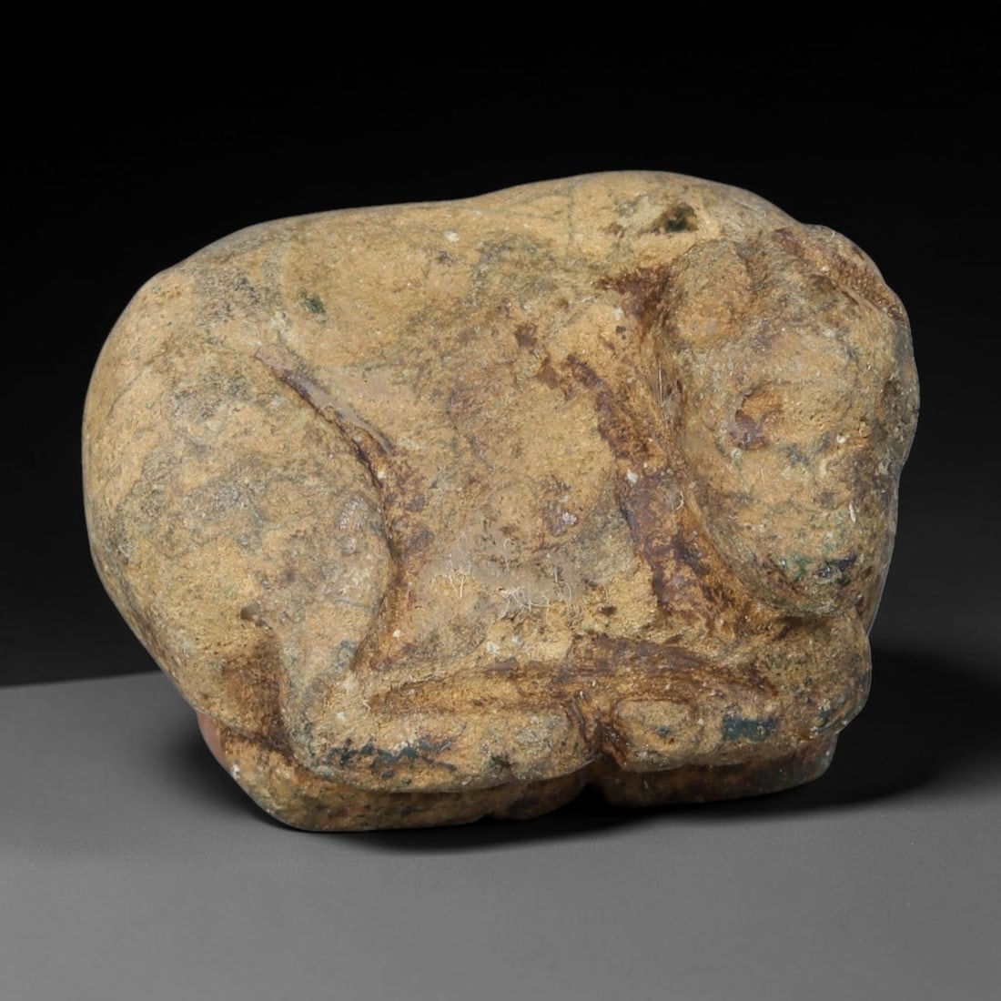 Ancient Achaemenid Persian Weathered Stone Recumbent Bovid Amulet (550-330 BCE), 36AB: This earth-toned mottled stone carving depicts a resting bovine figure, a common Zoroastrian ritual amulet from Achaemenid Persian culture symbolizing fertility and guardianship. Simple hand-carved co