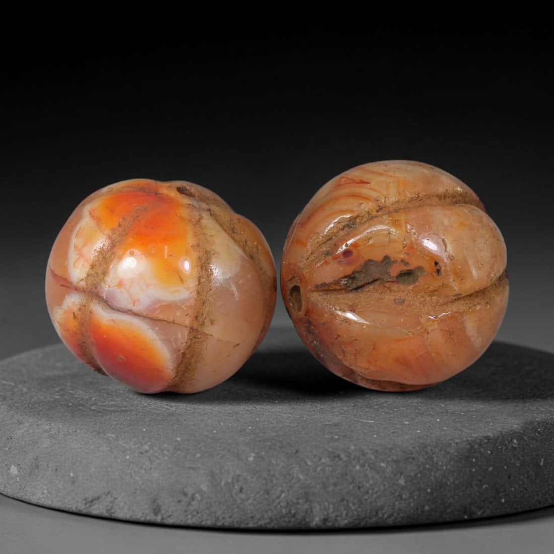 Ancient Medieval Khmer Angkor Culture Carved Carnelian Melon Bead Pair (802-1431 CE), 57AE: This matched pair of antique hand-carved melon form carnelian beads originates from Khmer Angkor Culture, the medieval Southeast Asian civilization renowned for crafting ritual chalcedony adornments f