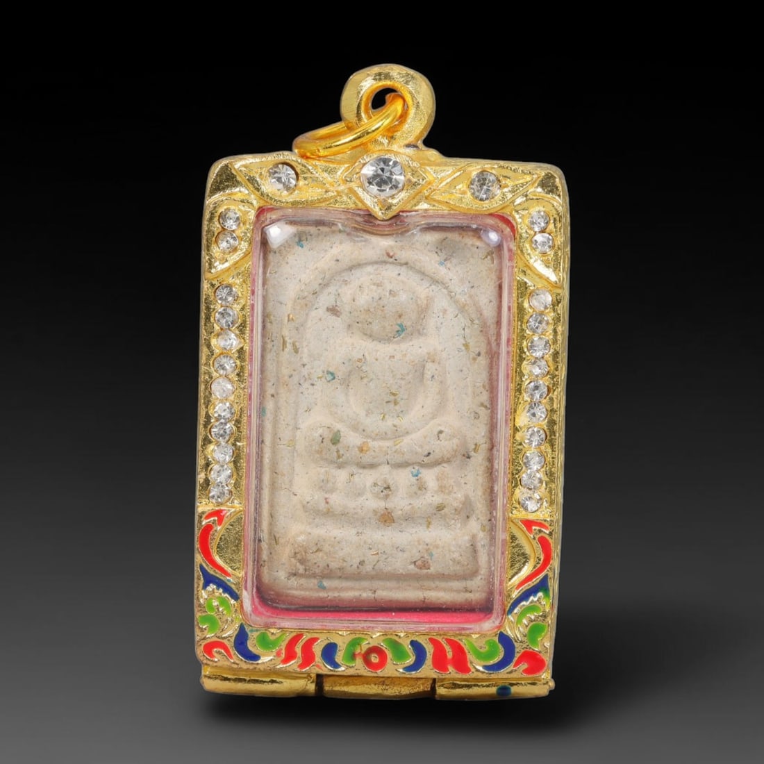 Thai Buddhist Folk Tradition Enclosed Amulet Pendant with Decorative Metal Casing, 10AH: This Thai sacred amulet is housed within an ornate hinged metal protective casing fitted with a top loop for wear as a pendant. The casing features intricate embossed surface detailing and a continuou