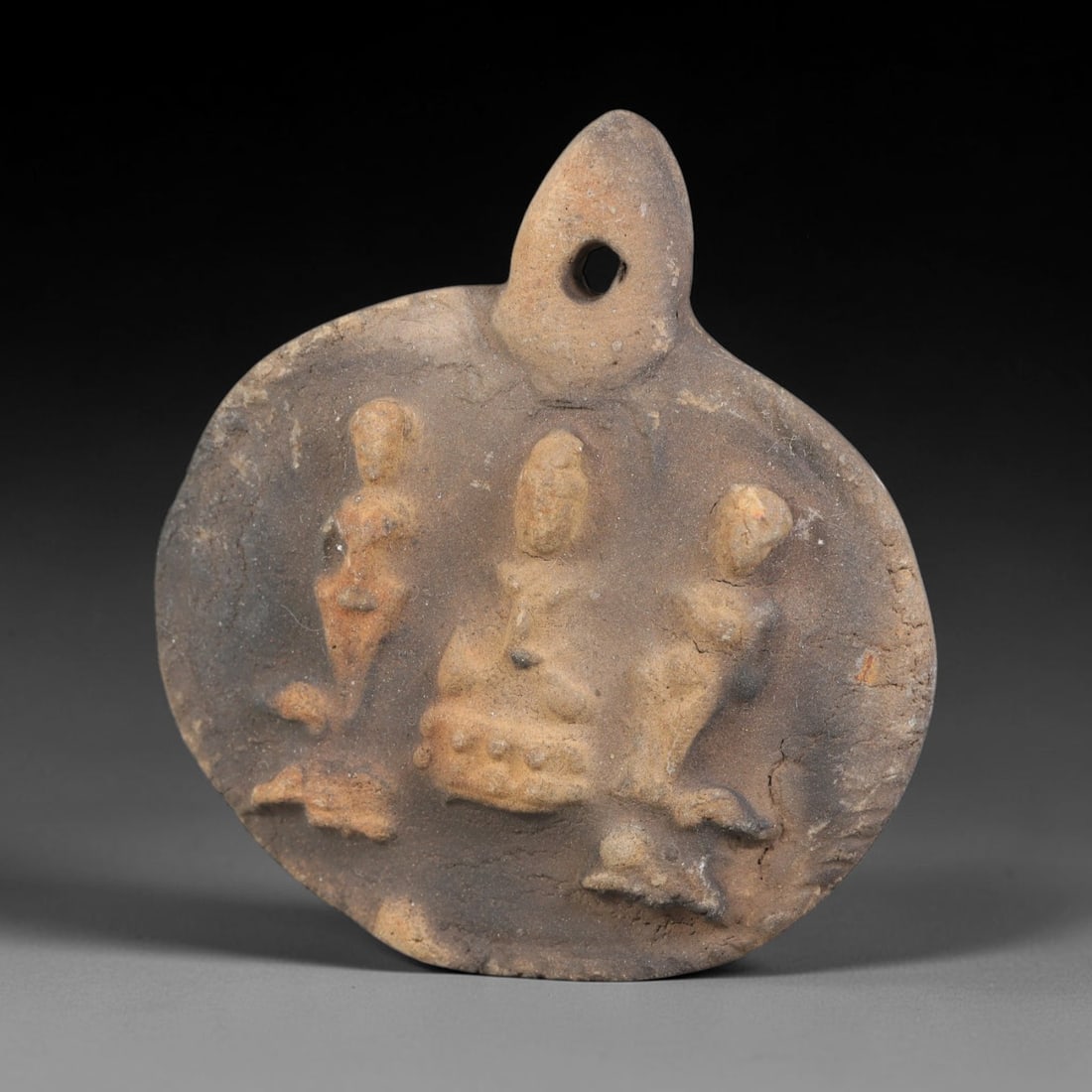 Ancient Gandhara Terracotta Buddhist Plaque (100 BCE-400 CE), 43EK: This ancient terracotta pendant plaque originates from Gandhara, a major centre of early Buddhist art along the Silk Road, shaped as a wearable devotional amulet with an integral suspension hole. The 
