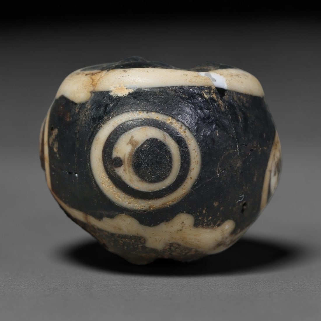 Ancient Islamic Hand Crafted Glass Bead Talisman, 28AC: Miniature antique wearable bead formed from hand-worked glass material, originating from ancient Islamic period glassmaking traditions across the Near East and North African cultural spheres. Glass wa