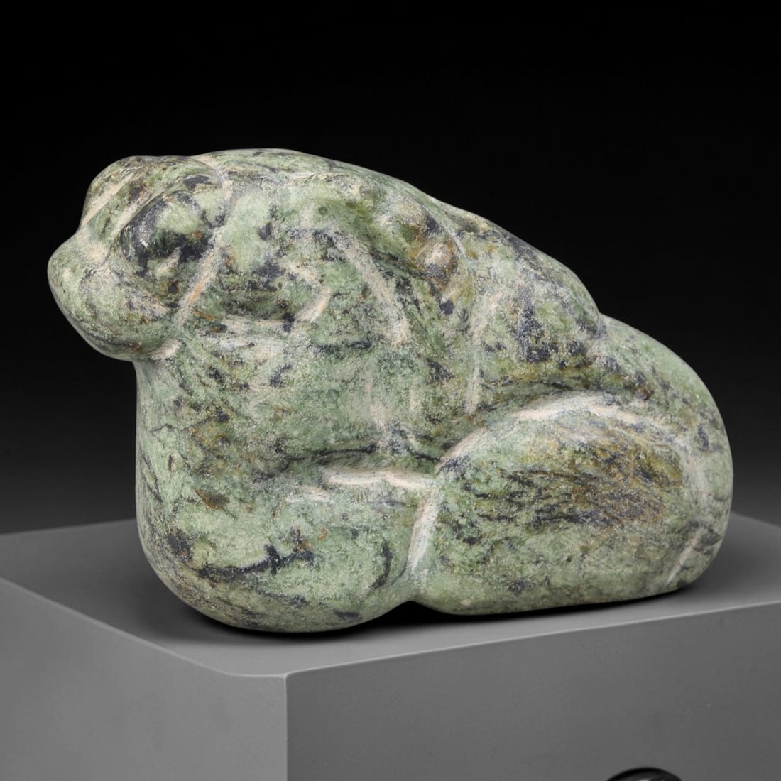 Ancient Egyptian Green Serpentine Recumbent Hare Amulet (664-30 BCE), 79AB: Hand-carved mottled green serpentine stone amulet depicting a crouched hare with smoothly rounded anatomical contours, simplified facial features and compact folded limbs typical of Egyptian miniature
