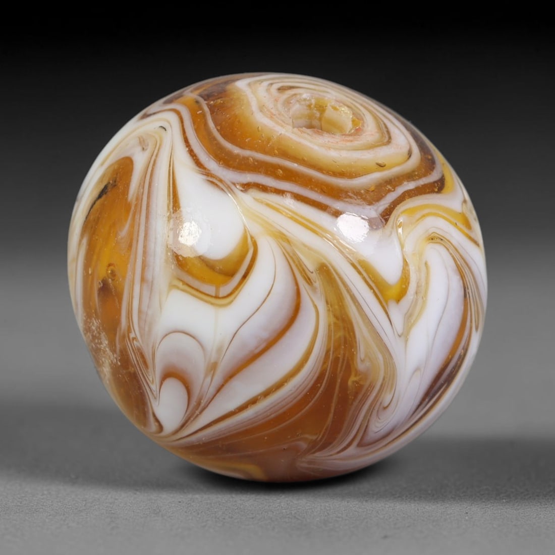 Swirled Amber Blown Glass Bead - Handmade Vintage Spherical Ornament, 14AE: Crafted by hand-blown glasswork, this spherical bead displays flowing marbled swirl strata of warm amber, honey gold, and opaque white glass that ripple uniformly across its polished exterior. Minor n