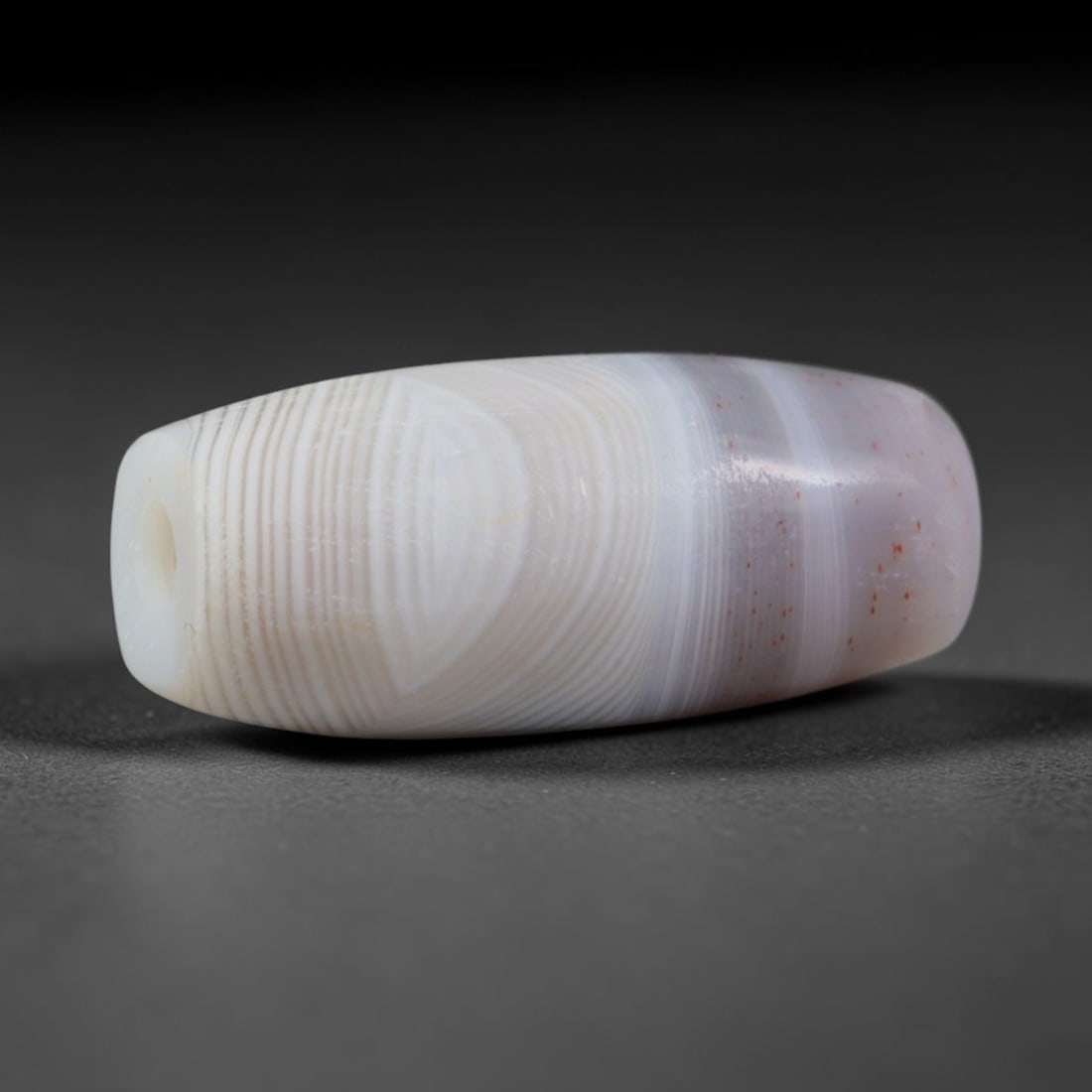 Ancient Ghaznavid & Seljuk Central Asian Banded Agate Barrel Bead (977-1243 CE), 2AD: This antique banded agate barrel bead originates from Ghaznavid and Seljuk Central Asian lapidary traditions, master artisans who carried forward Persian chalcedony carving expertise to produce banded