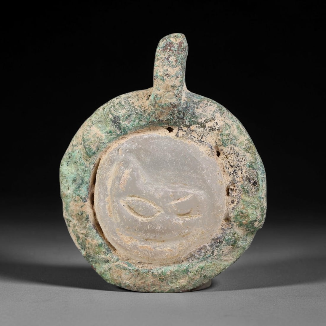 Ancient Medieval Byzantine Bronze Pendant With Stone Cameo (500-1200 CE), 73EH: This antique circular bronze pendant originates from medieval Byzantine cultural tradition, set with an inset carved stone cameo and made to serve as a wearable protective personal amulet. The bronze 