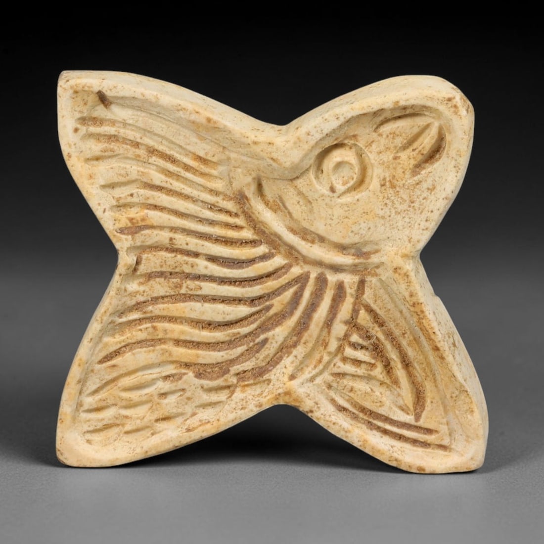 Ancient Neo-Hittite Quadrilobed Limestone Fish Motif Stamp Seal (1200-800 BCE), 36EF: This four-lobed cross-form stamp seal is carved from pale limestone, originating from Iron Age Neo-Hittite cultures of Northern Syria and Eastern Anatolia. The seal face features an intaglio stylized 