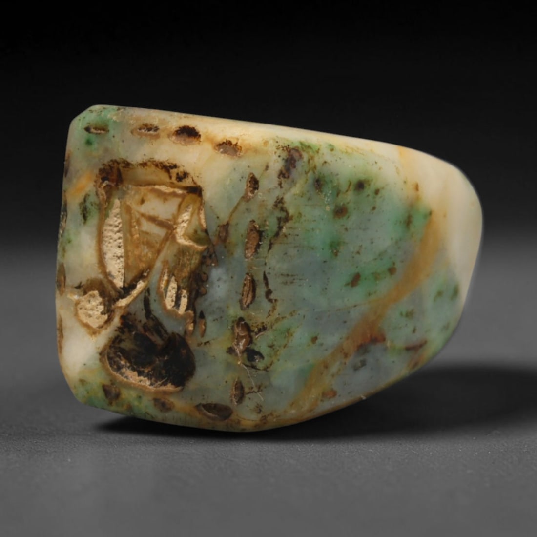 Ancient Sasanian Persian Conoid Stamp Seal with Noble Head Motif (c.224-651 CE), 25ED: This variegated green and cream stone conoid stamp seal originates from Ancient Sasanian Persian culture. The flat sealing face features an incised noble head motif, surrounded by decorative punctate 