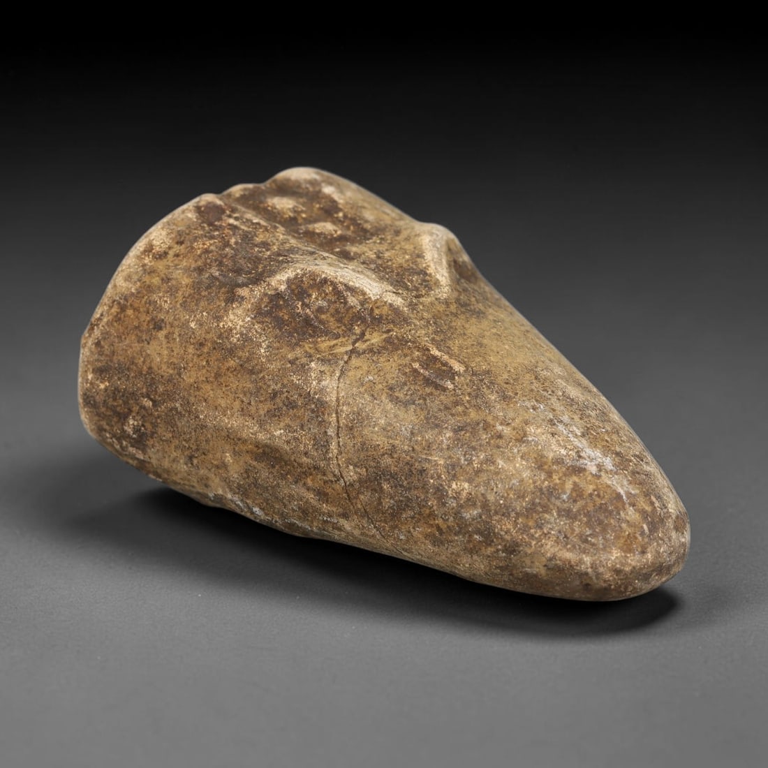 Ancient Medieval Near Eastern Stone Zoomorphic Head (600-1100 CE), 79EJ: This antique stone zoomorphic head originates from medieval Near Eastern cultural tradition, created for ceremonial and talismanic function. The dense stone bears heavy agerelated patina, surface eros