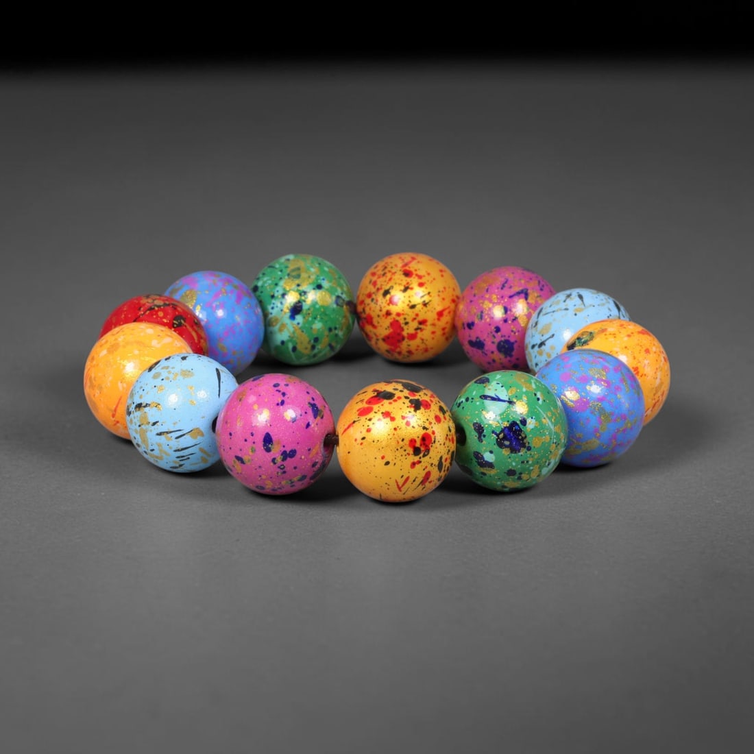 A Chinese Artistic Paint Wood Beaded Bracelet, 17mm Beads, 67BX: Completed bracelet assembled from wooden spherical beads with distinctive artistic paint finish, each bead measuring 17 mm. Vibrant multi-tonal speckled surface detailing is applied across each bead, 