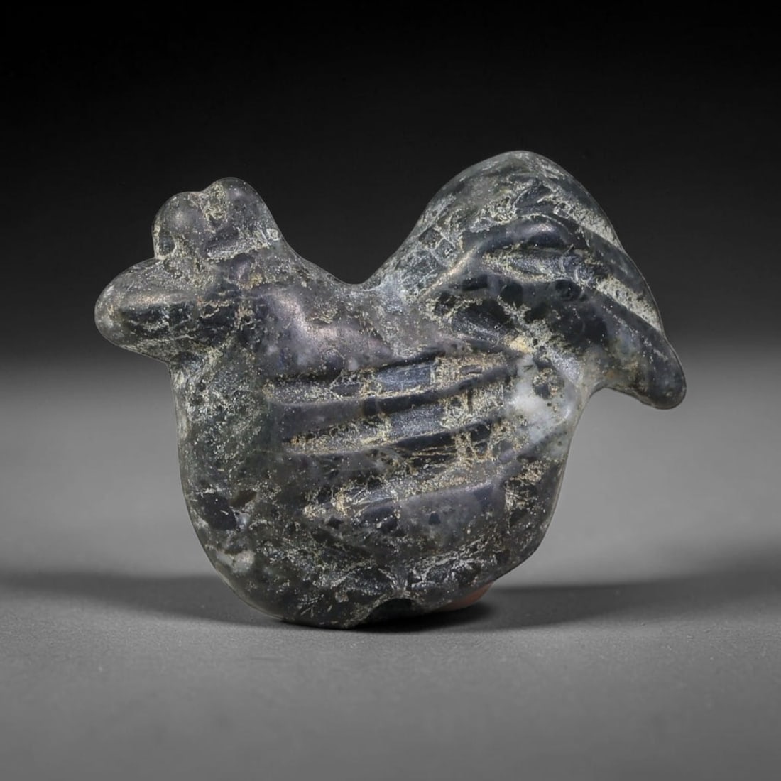 Ancient Sasanian Persian Dark Stone Cockerel Amulet Bead (224-651 CE), 56FV: This antique cockerel amulet bead originates from the Sasanian Persian Empire, where rooster zoomorphic talismans symbolised vigilance, light and warding off evil spirits. The stylized bird carving fe