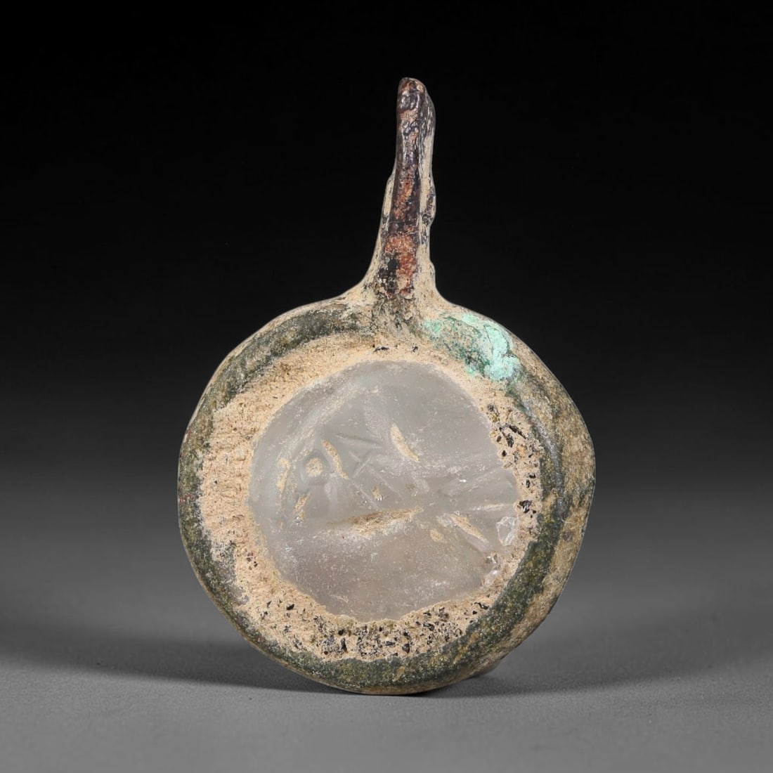 Ancient Medieval Byzantine Bronze Pendant With Stone Cameo (500-1200 CE), 45EH: This antique circular bronze pendant originates from medieval Byzantine cultural tradition, set with an inset carved stone cameo and made to serve as a wearable protective personal amulet. The bronze 