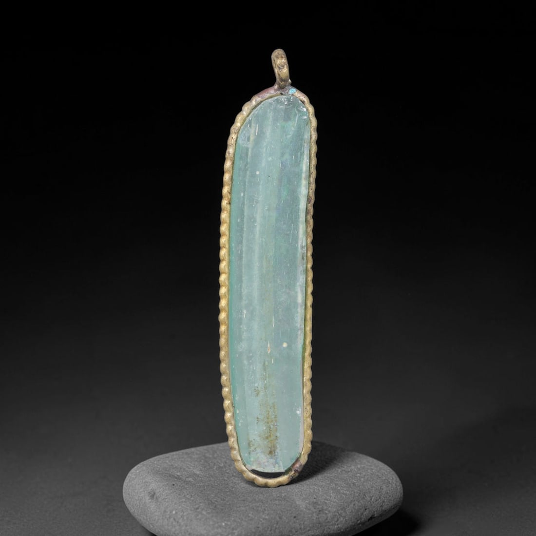 Ancient Roman Glass Slag in Modern Gilt-Edge Pendant, 39EH: This contemporary pendant is crafted from ancient Roman glass slag, featuring a fragmented, iridescent glass surface with weathered patina. The irregular form is bordered by a subtle gilt frame, added