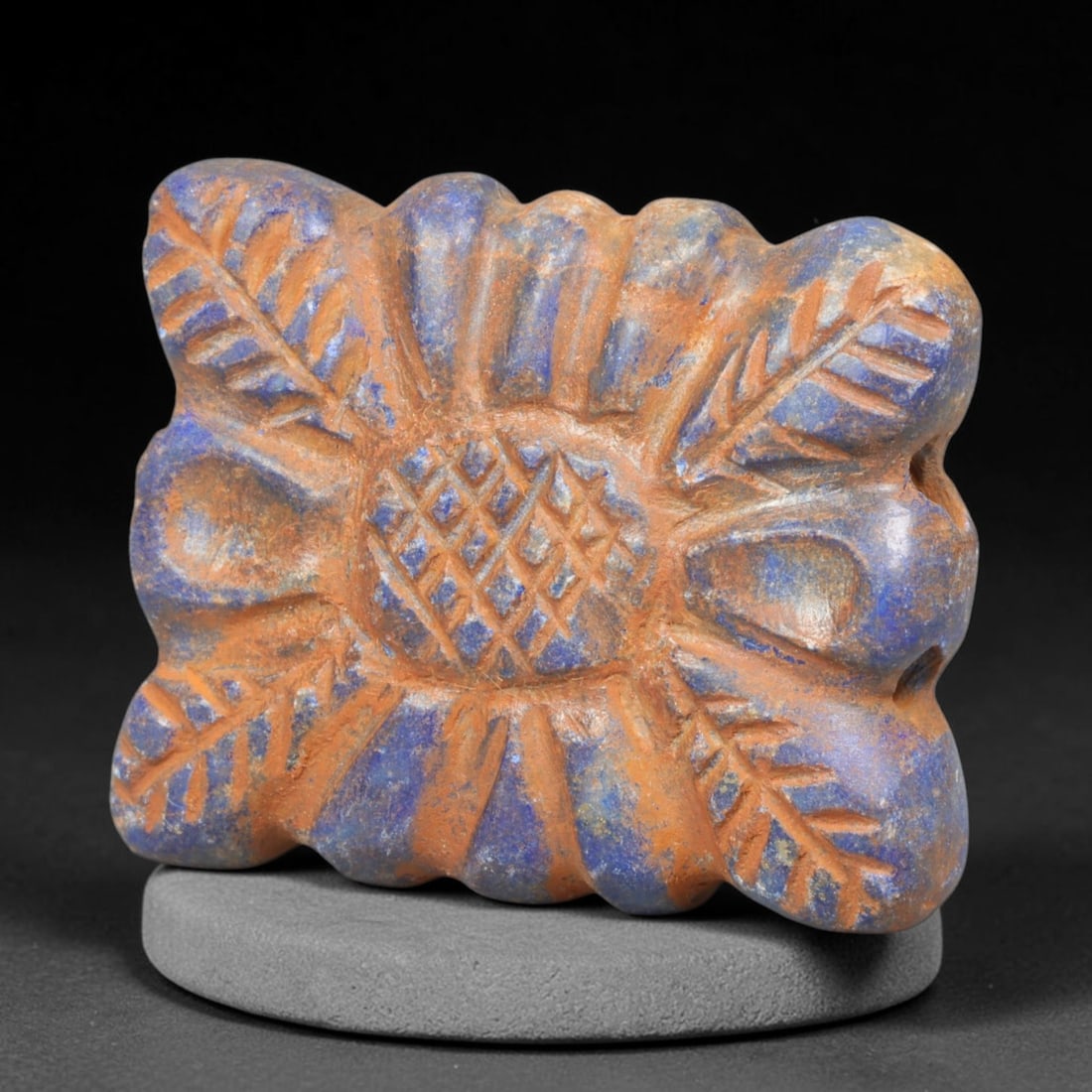 Ancient Achaemenid Persian Lapis Lazuli Rosette Bead (550-330 BCE), 47EQ: This finely carved pendant bead is fashioned from rich lapis lazuli originating from the Achaemenid Persian Empire, decorated with a symmetrical rosette floral motif featuring incised leaf and lattice