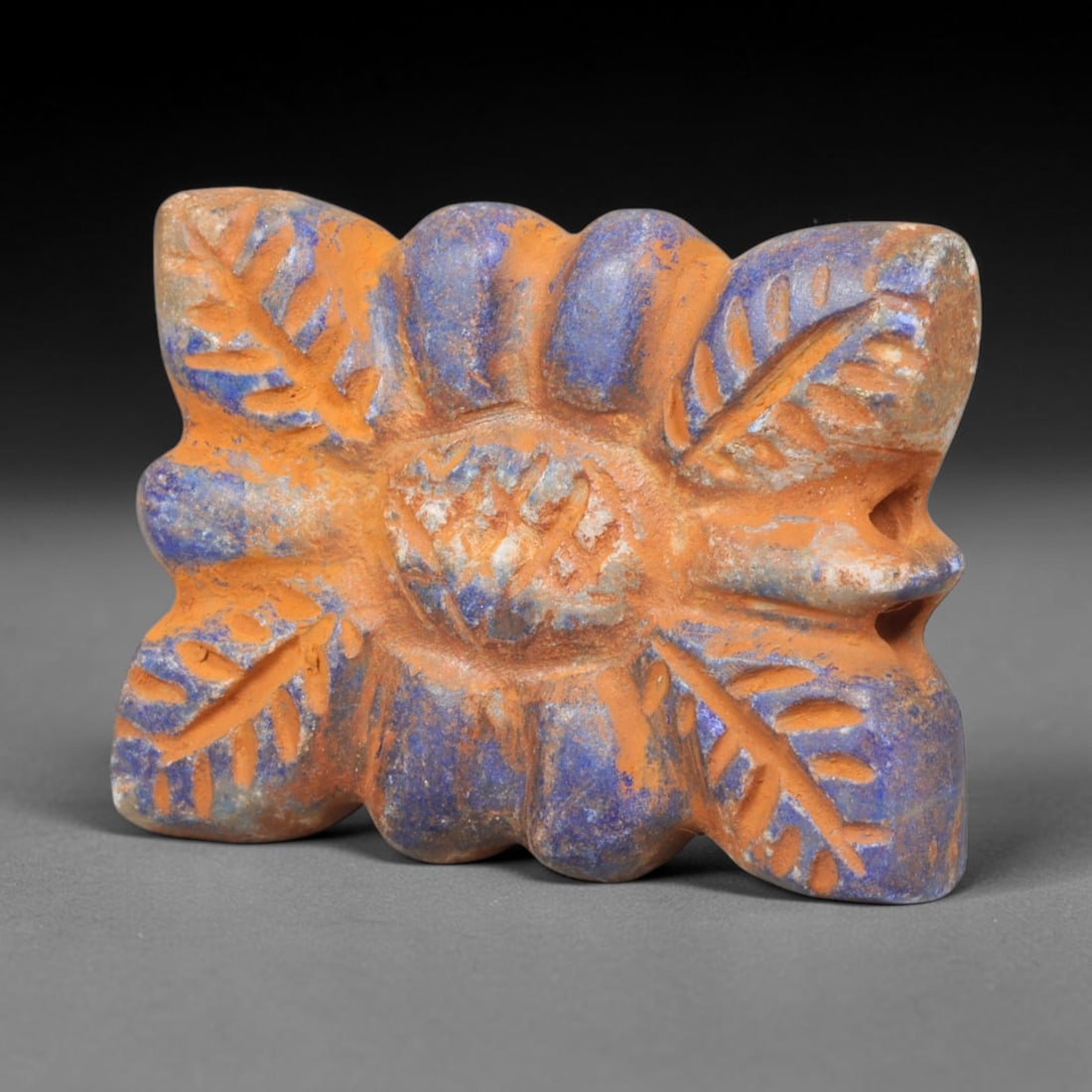 Ancient Achaemenid Persian Lapis Lazuli Rosette Bead (550-330 BCE), 81EQ: This finely carved pendant bead is fashioned from rich lapis lazuli originating from the Achaemenid Persian Empire, decorated with a symmetrical rosette floral motif featuring incised leaf and lattice