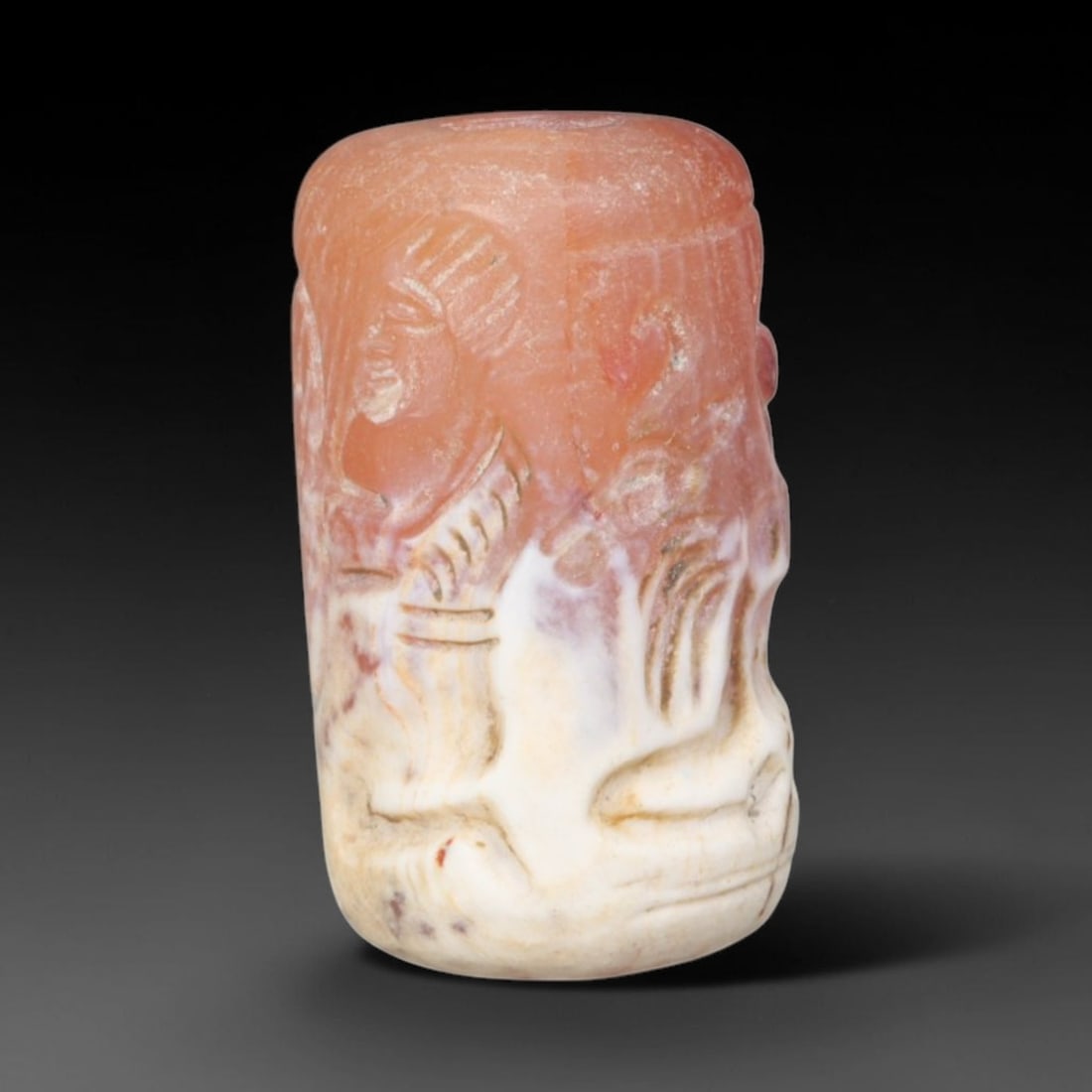 Ancient Achaemenid Persian Carnelian Cylinder Seal (550-330 BCE), 91EQ: This cylindrical seal is carved from warm translucent carnelian originating from the Achaemenid Persian cultural sphere, engraved with a scene featuring a standing human figure confronting a horned be