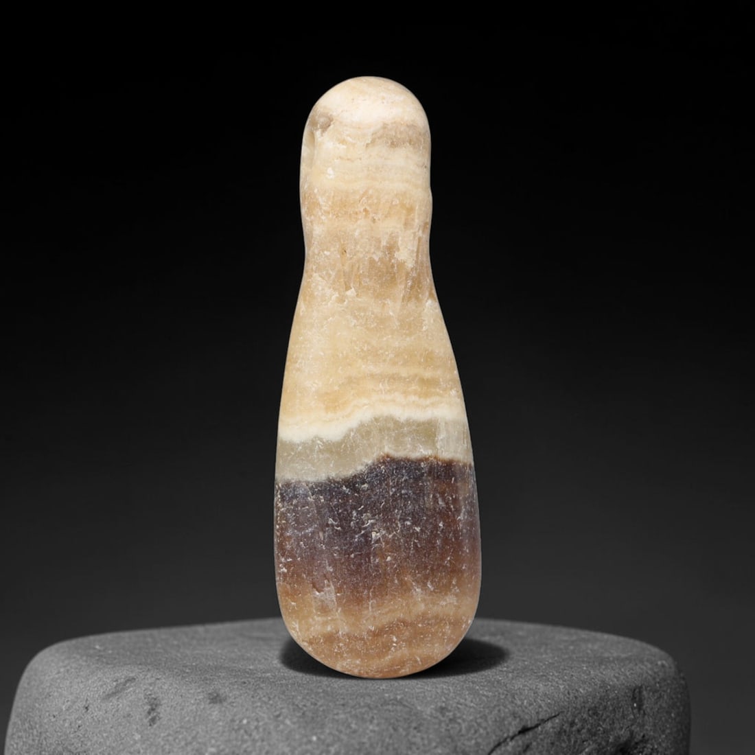 Ancient Roman Banded Calcite Teardrop Pendant Amulet (1st-3rd Century CE), 86EQ: Polished from layered banded calcite stone originating within the territories of the Roman Empire. This teardrop-shaped wearable pendant features a smoothly tapered silhouette with a small perforation