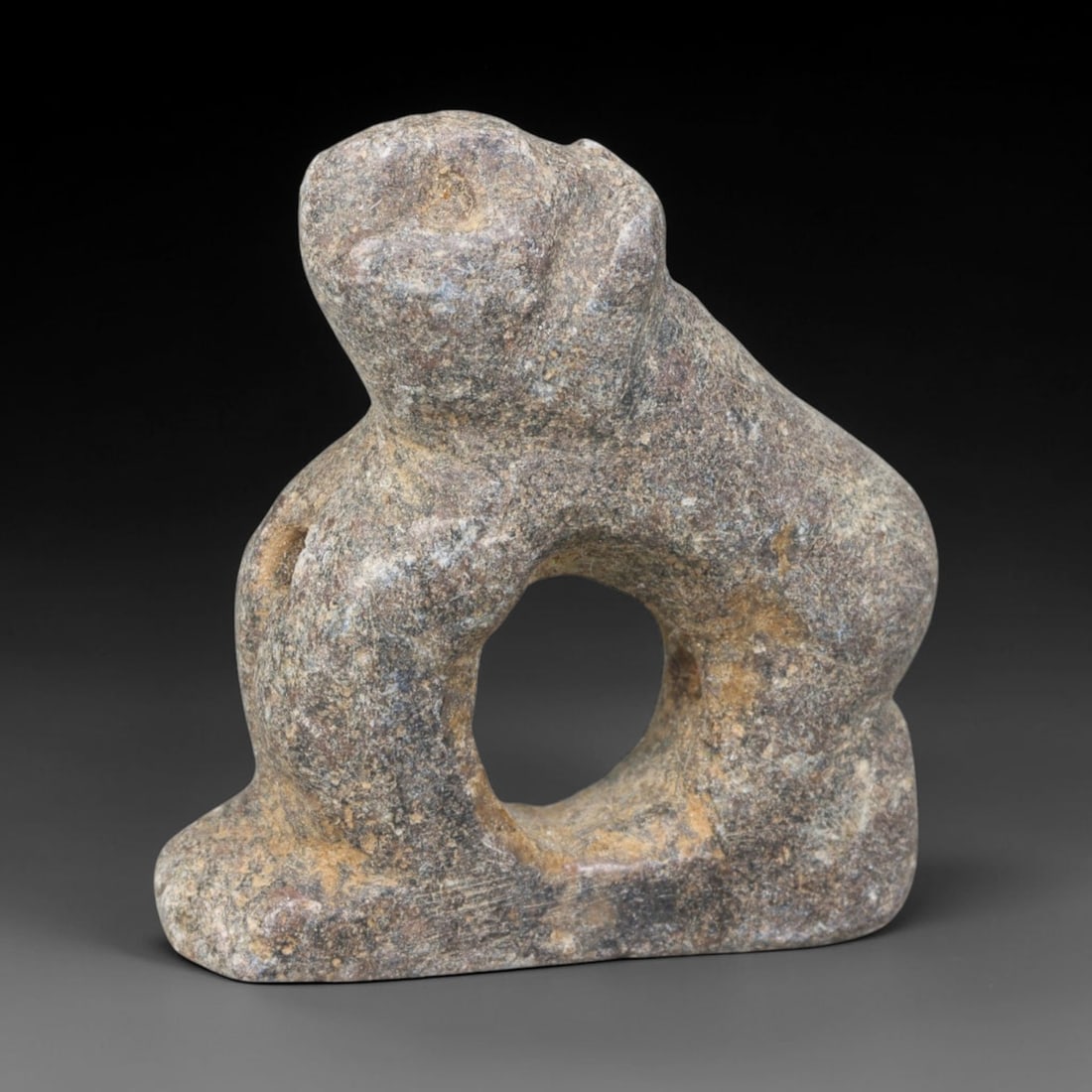 Ancient Medieval Seljuk Islamic Zoomorphic Guardian Amulet (c.1037-1194 CE), 85EQ: Hand-carved from dark mottled metamorphic stone originating from medieval Seljuk Iran. This compact talisman is modelled as a stylised crouched zoomorphic guardian figure integrated with a large centr
