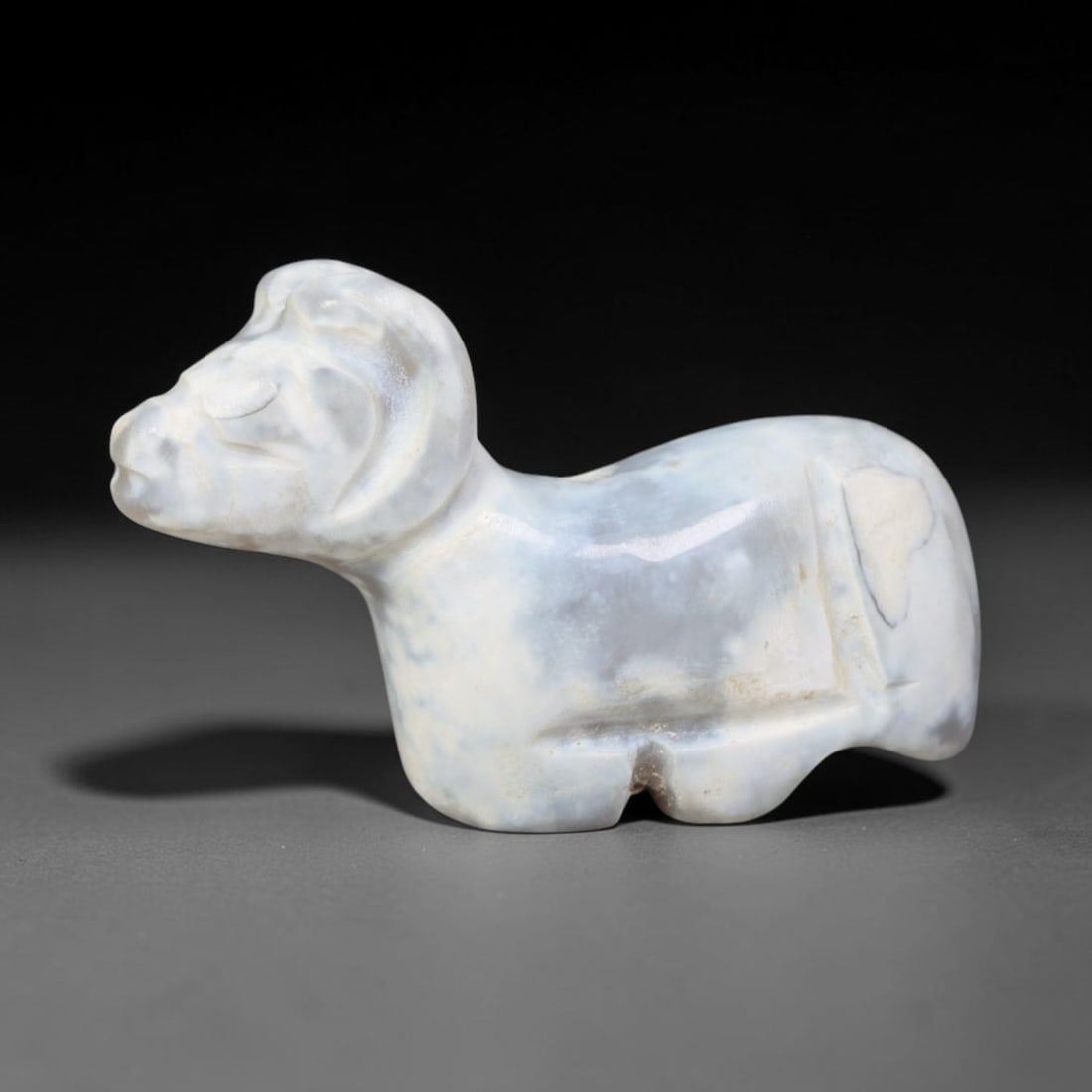 Ancient Bactrian White Chalcedony Ram Effigy Amulet (c.200-200 BCE), 71EQ: Carved from milky white banded chalcedony originating within ancient Bactria, Central Asia. Modelled as a recumbent ram in compact miniature form, this wearable zoomorphic talisman features simplified