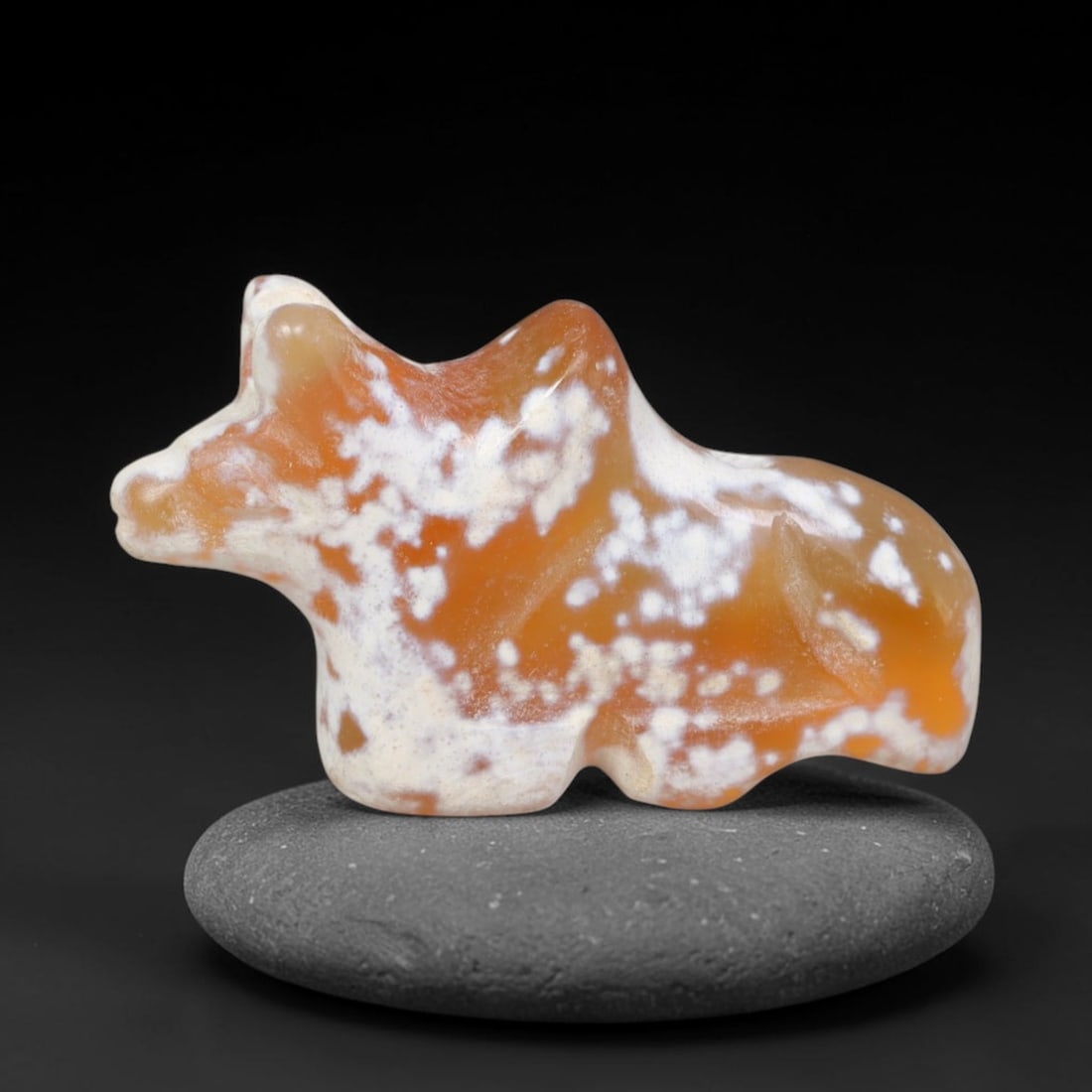 Ancient Bactrian Carnelian Bovid Effigy Amulet (c.200-200 BCE), 63EQ: Hand-carved from warm orange carnelian originating within ancient Bactria, Central Asia. Crafted as a stylised recumbent bovine talisman with streamlined minimal carving typical of Bactrian zoomorphic