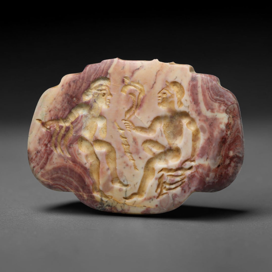 Ancient Sasanian Persian Banded Rhodochrosite Intaglio Plaque (224-651 CE), 53ED: This antique banded rhodochrosite intaglio plaque originates from Ancient Sasanian Persian civilisation. The naturally patterned pink and white banded stone bears finely engraved imagery depicting two