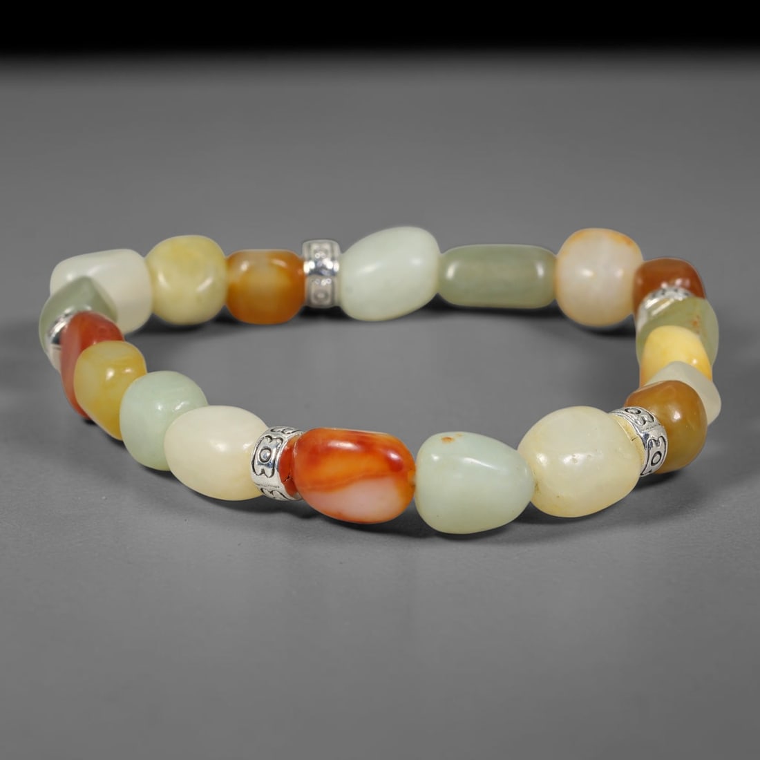 Natural Chinese Hetian Nephrite Jade Tumbled Beaded Bracelet, 33FJ: Features polished natural Chinese Hetian nephrite jade freeform tumbled beads paired with decorative accent elements. Approximate bead size 7mm, arranged into a flexible wearable strand. Each bead car