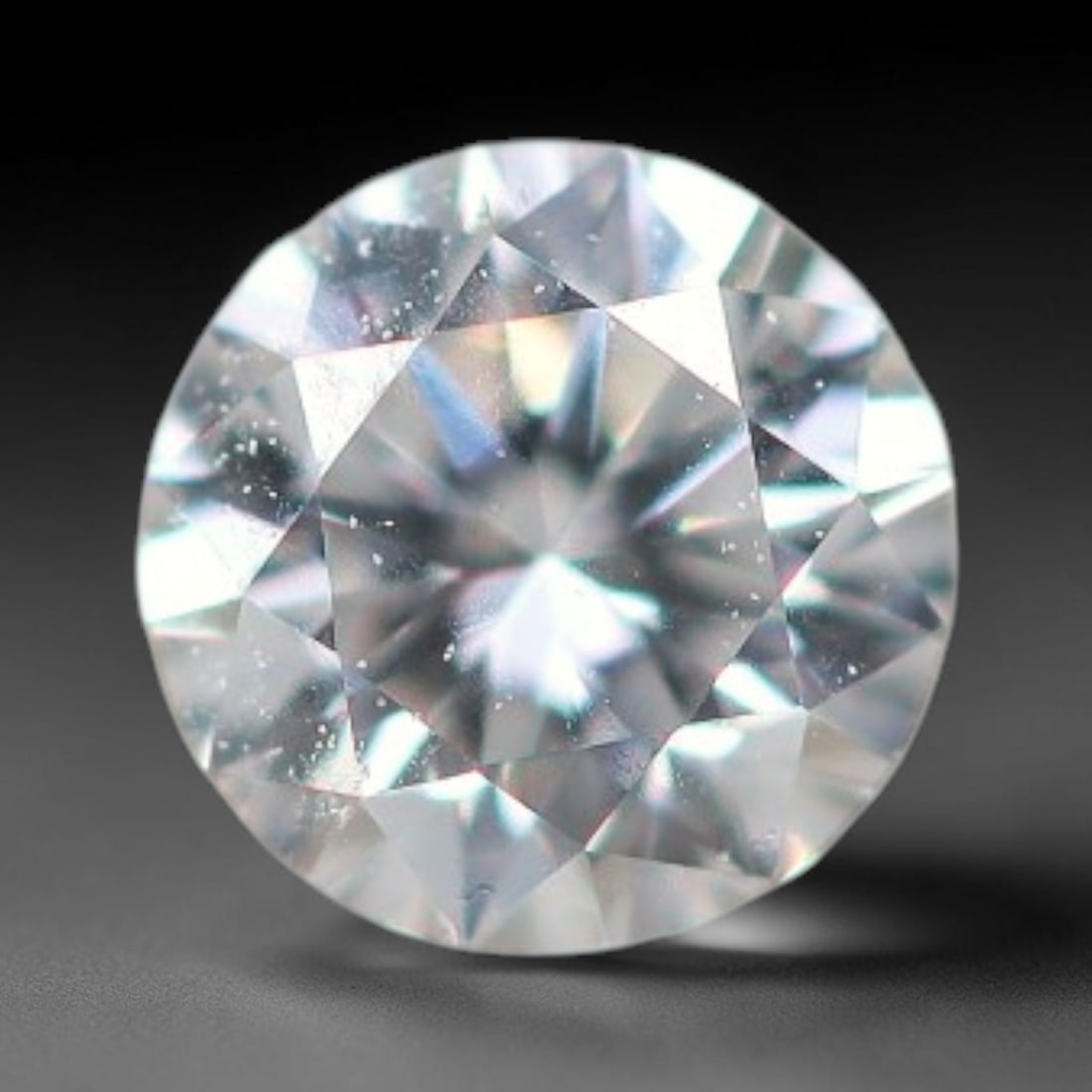 0.11ct Lab-Grown White Round Brilliant HPHT Diamond Loose Gemstone, 79BE: This precision-cut HPHT lab-grown diamond exhibits brilliant colourless transparency, dotted with subtle microscopic growth features within its crystal structure, measured at calibrated dimensions of 