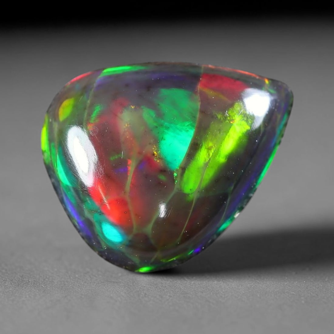 2.21ct Natural Ethiopian Welo Black Smoked Opal Cabochon Loose Gemstone, 19FX: This fully polished Ethiopian Welo opal features a dark smoked base with vivid, sweeping play-of-color shifting across its glossy dome surface, measured at 11x10x4mm. The black smoke treatment deepens