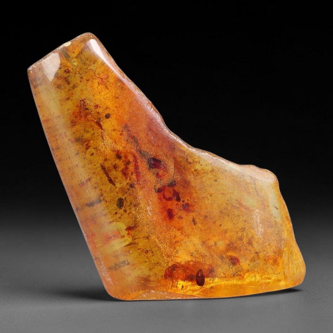 14.94ct Natural Baltic Polished Loose Freeform Amber Gemstone, 24EB: This smoothly polished freeform amber piece carries warm translucent organic clarity with fine natural fossil flecks and tiny mineral inclusions suspended throughout its 30x20mm flowing unstructured s