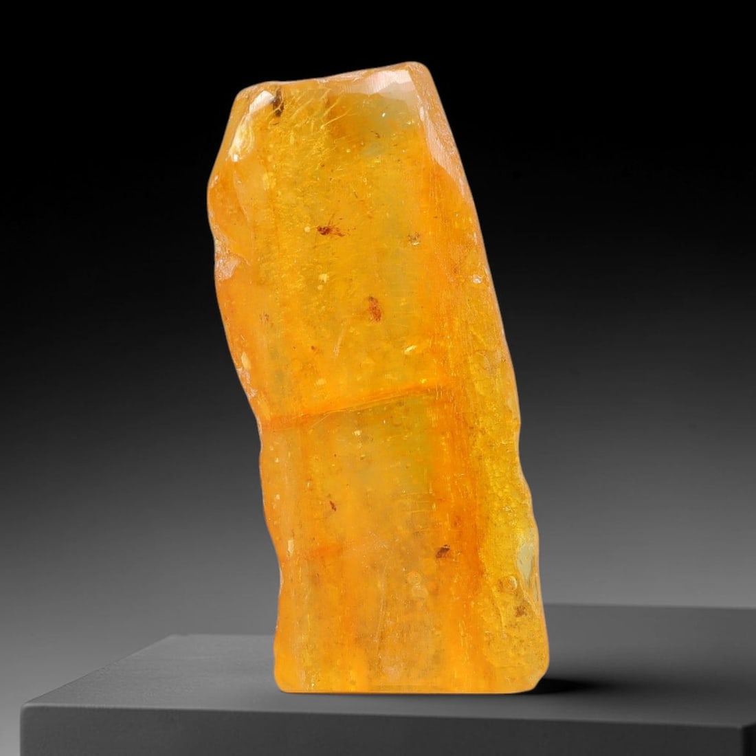 12.95ct Natural Baltic Polished Loose Freeform Amber Gemstone, 35EB: This smoothly polished freeform amber piece carries warm translucent organic clarity with fine natural fossil flecks and tiny mineral inclusions suspended throughout its 31x13mm flowing unstructured s