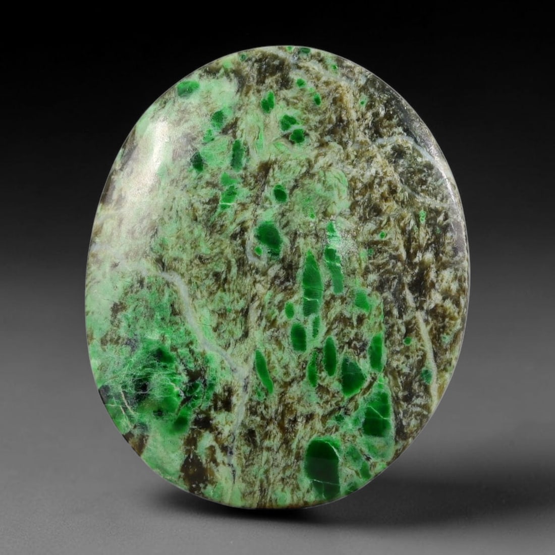 13.62ct Natural Burmese Type A Emerald Fragment Scenic Matrix Jadeite Jade Cabochon, 23FA: This single untreated natural Burmese Type A oval jadeite jade cabochon weighs 13.62ct with dimensions of 25x20.8x3.3mm. The earthy brown fibrous host matrix is embedded with numerous bright emerald g