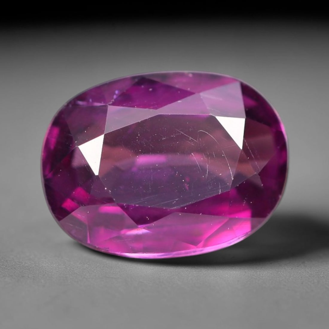 1.57ct Natural Tanzanian Rhodolite Grape Garnet Faceted Loose Gemstone, 100BF: This expertly faceted grape garnet, a scarce saturated purple-magenta rhodolite variant, features transparent crystal structure dotted with faint microscopic mineral specks within its precisely cut re