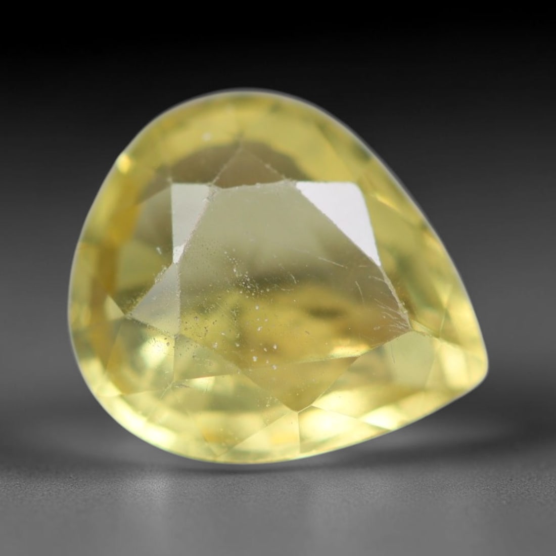 2.16ct Natural Mexican Lemon Yellow Faceted Apatite Loose Gemstone, 66BC: This expertly faceted yellow apatite holds translucent pale lemon yellow crystal structure with faint tiny internal mineral specks and subtle fine linear markings visible beneath its precisely polishe