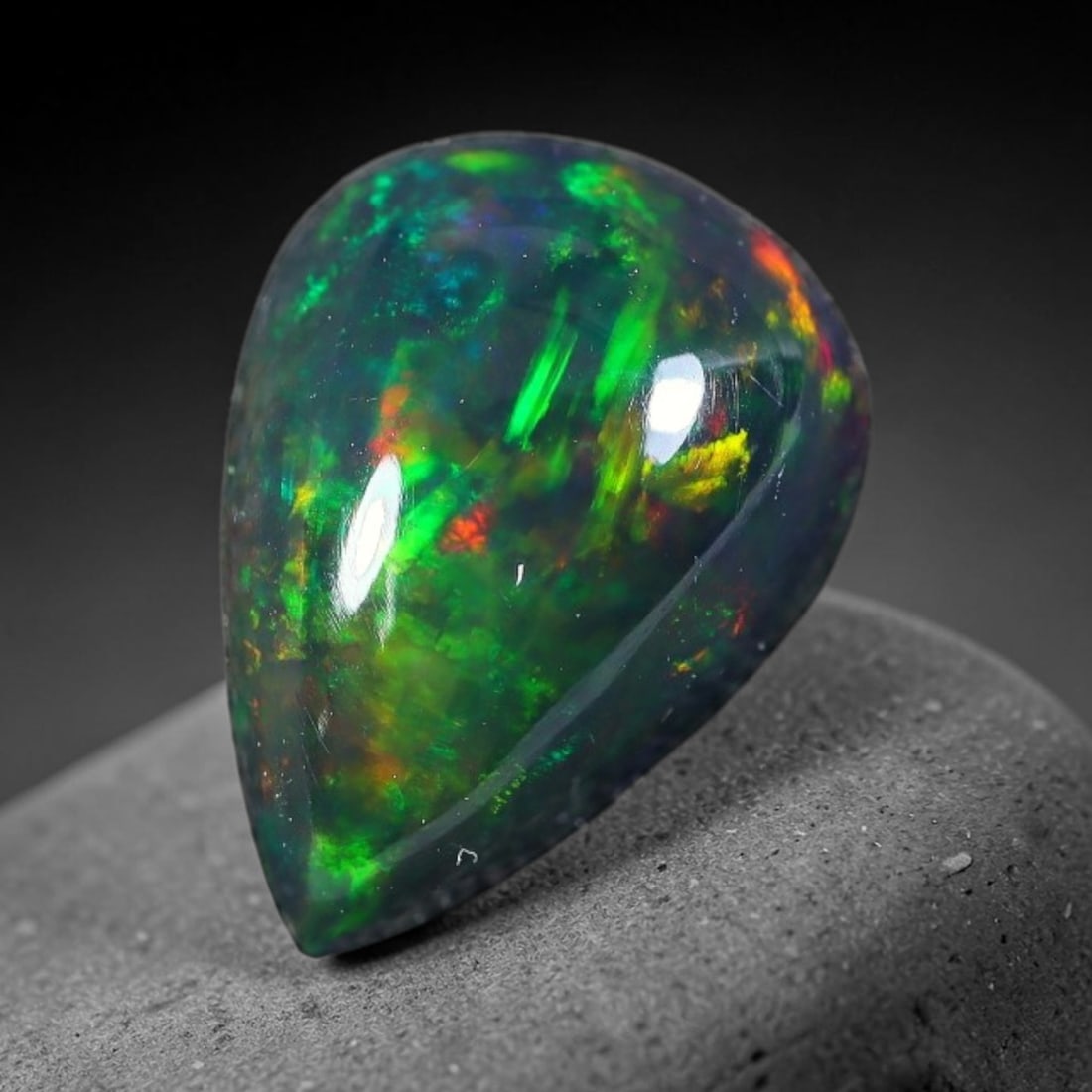 2.02ct Natural Ethiopian Welo Black Smoked Opal Cabochon Loose Gemstone, 18FX: This fully polished Ethiopian Welo opal features a dark smoked base with vivid, sweeping play-of-color shifting across its glossy dome surface, measured at 10x8x5mm. The black smoke treatment deepens 