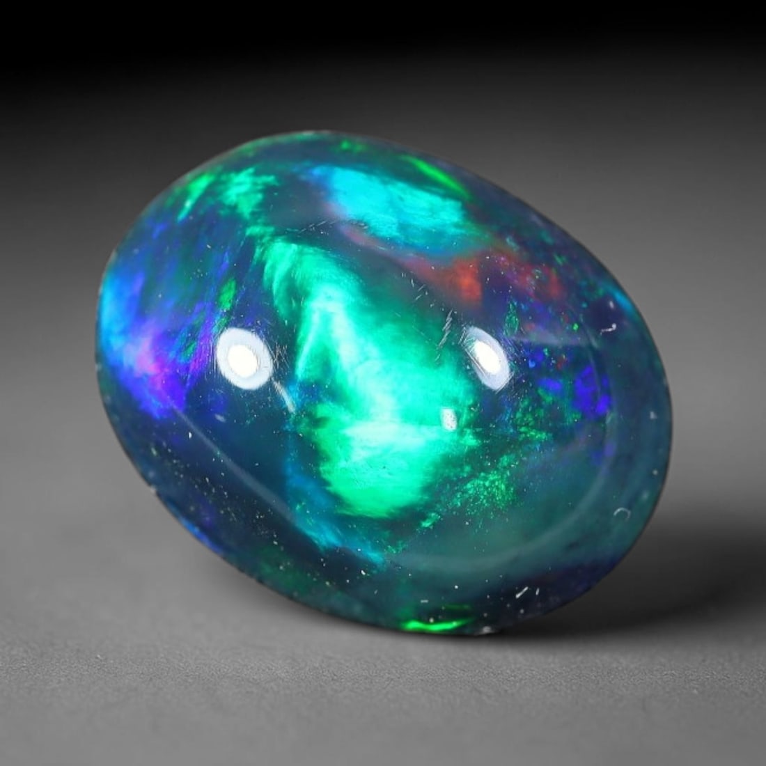 2.00ct Natural Ethiopian Welo Black Smoked Opal Cabochon Loose Gemstone, 78FX: This fully polished Ethiopian Welo opal features a dark smoked base with vivid, sweeping play-of-color shifting across its glossy dome surface, measured at 10x8x4mm. The black smoke treatment deepens 