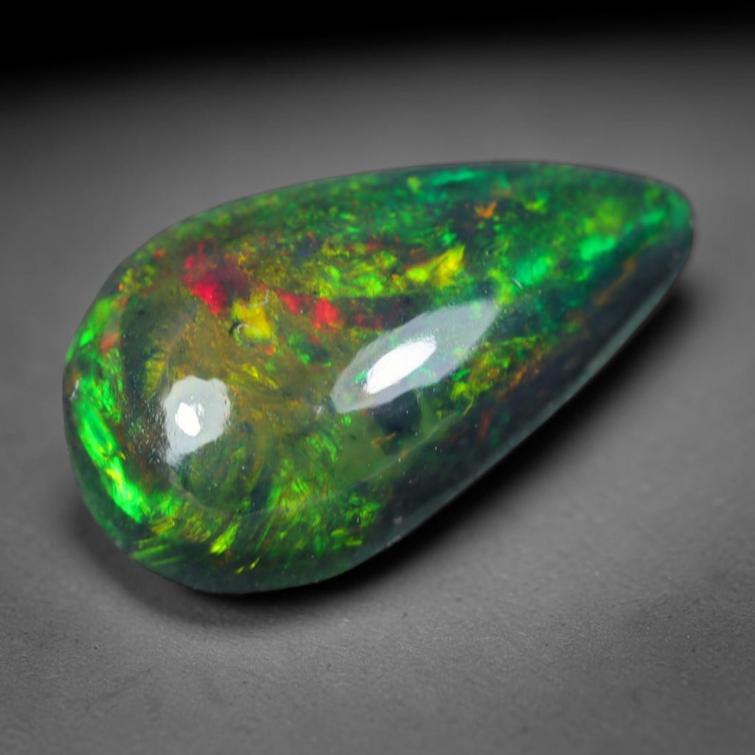 2.48ct Natural Ethiopian Welo Black Smoked Opal Cabochon Loose Gemstone, 73AK: This fully polished Ethiopian Welo opal features a dark smoked base with vivid, sweeping play-of-color shifting across its glossy dome surface, measured at 13.4x7.8x5.1mm. The black smoke treatment de