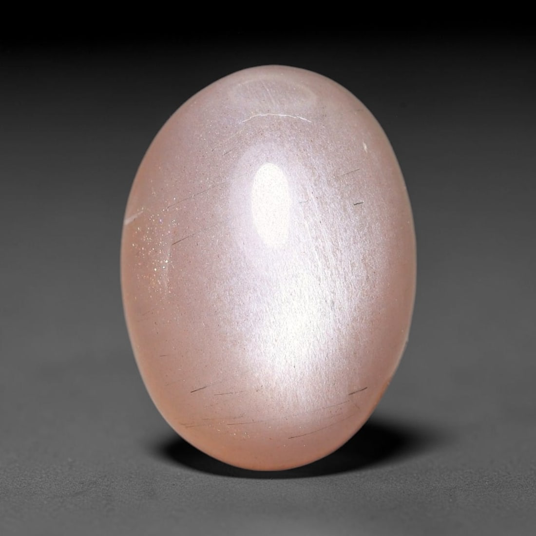 7.91ct Natural Ceylon Warm Peach Moonstone Loose Gemstone, 4FJ: This natural Ceylon moonstone has dimension measurements of 15x11x6mm, showcasing a smooth warm peach base tone paired with subtle soft adularescent sheen that glides gently across the polished surfac