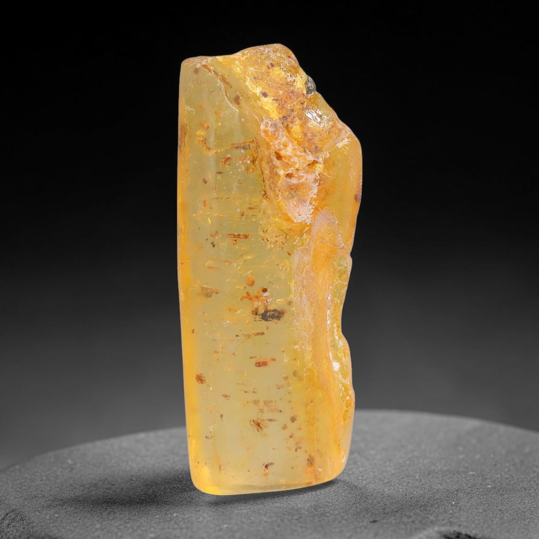 15.70ct Natural Baltic Polished Loose Freeform Amber Gemstone, 34EB: This smoothly polished freeform amber piece carries warm translucent organic clarity with fine natural fossil flecks and tiny mineral inclusions suspended throughout its 34x16mm flowing unstructured s