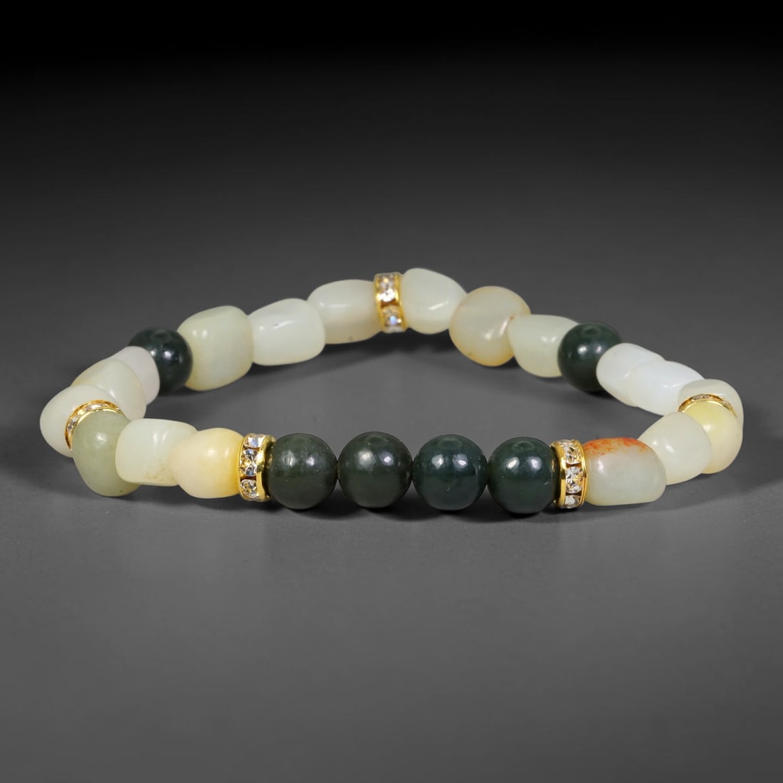 Natural Chinese Hetian Nephrite Jade Beaded Bracelet, 23EP: This assembled bracelet features genuine Chinese Hetian nephrite jade beads, paired with elegant gold-toned crystal-set spacer accents. Polished for a smooth finish, it suits daily wear as well as col