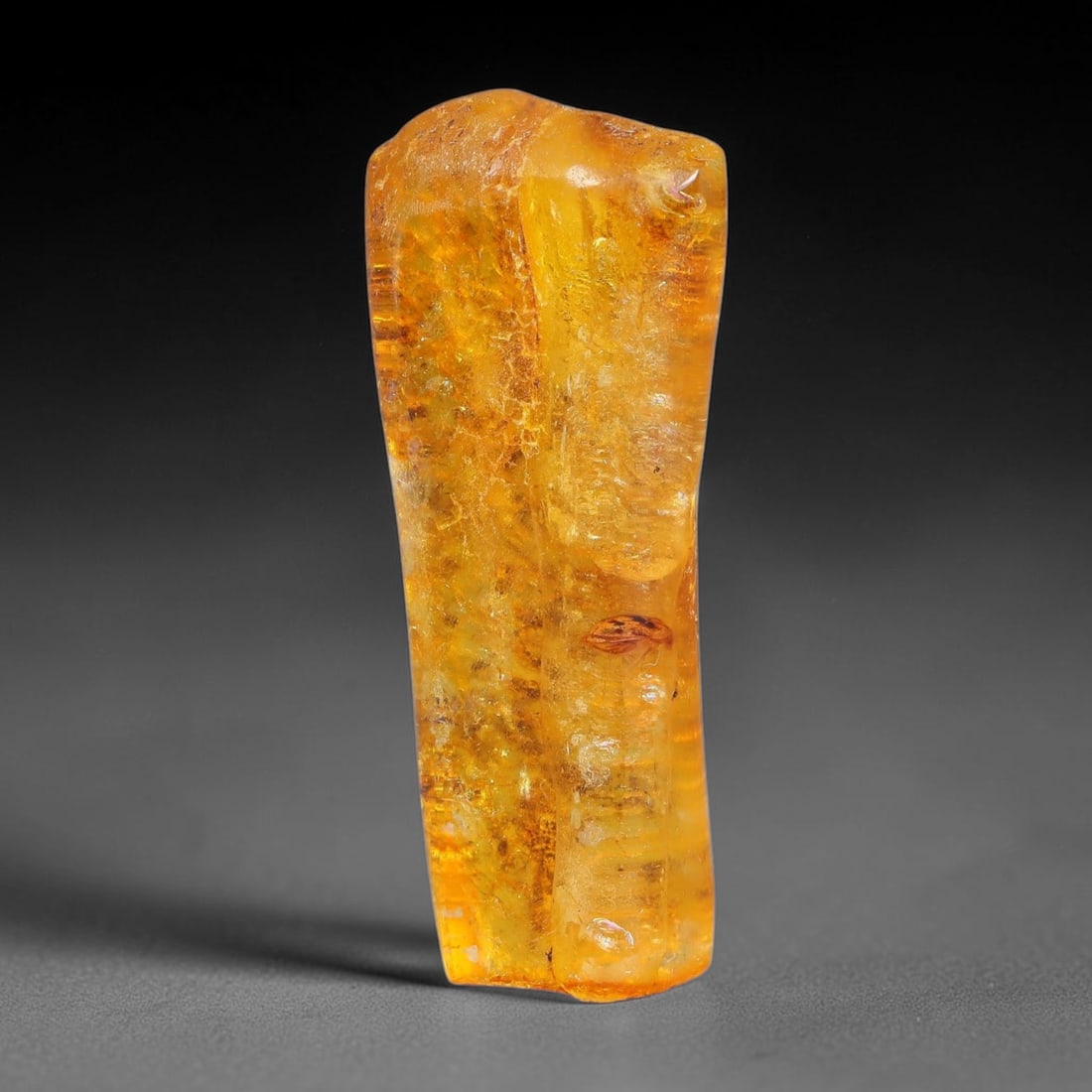 10.23ct Natural Baltic Polished Loose Freeform Amber Rough, 32EK: This smoothly polished freeform amber piece carries warm translucent organic clarity with fine natural fossil flecks and tiny mineral inclusions suspended throughout its 33x14x6mm flowing unstructured