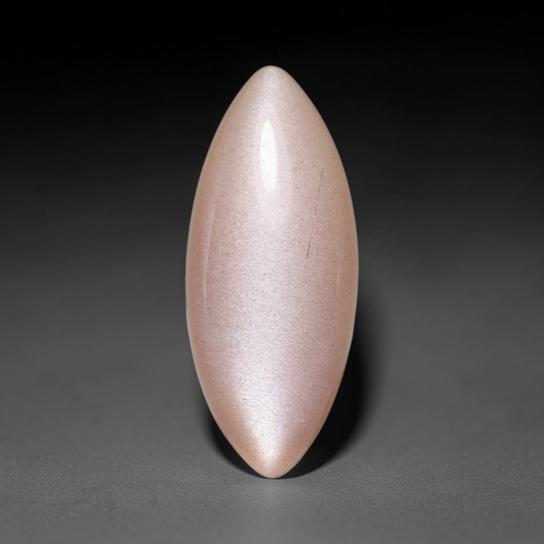 6.00ct Natural Ceylon Warm Peach Moonstone Loose Gemstone, 82FX: This natural Ceylon moonstone has dimension measurements of 20x8x5mm, showcasing a smooth warm peach base tone paired with subtle soft adularescent sheen that glides gently across the polished surface
