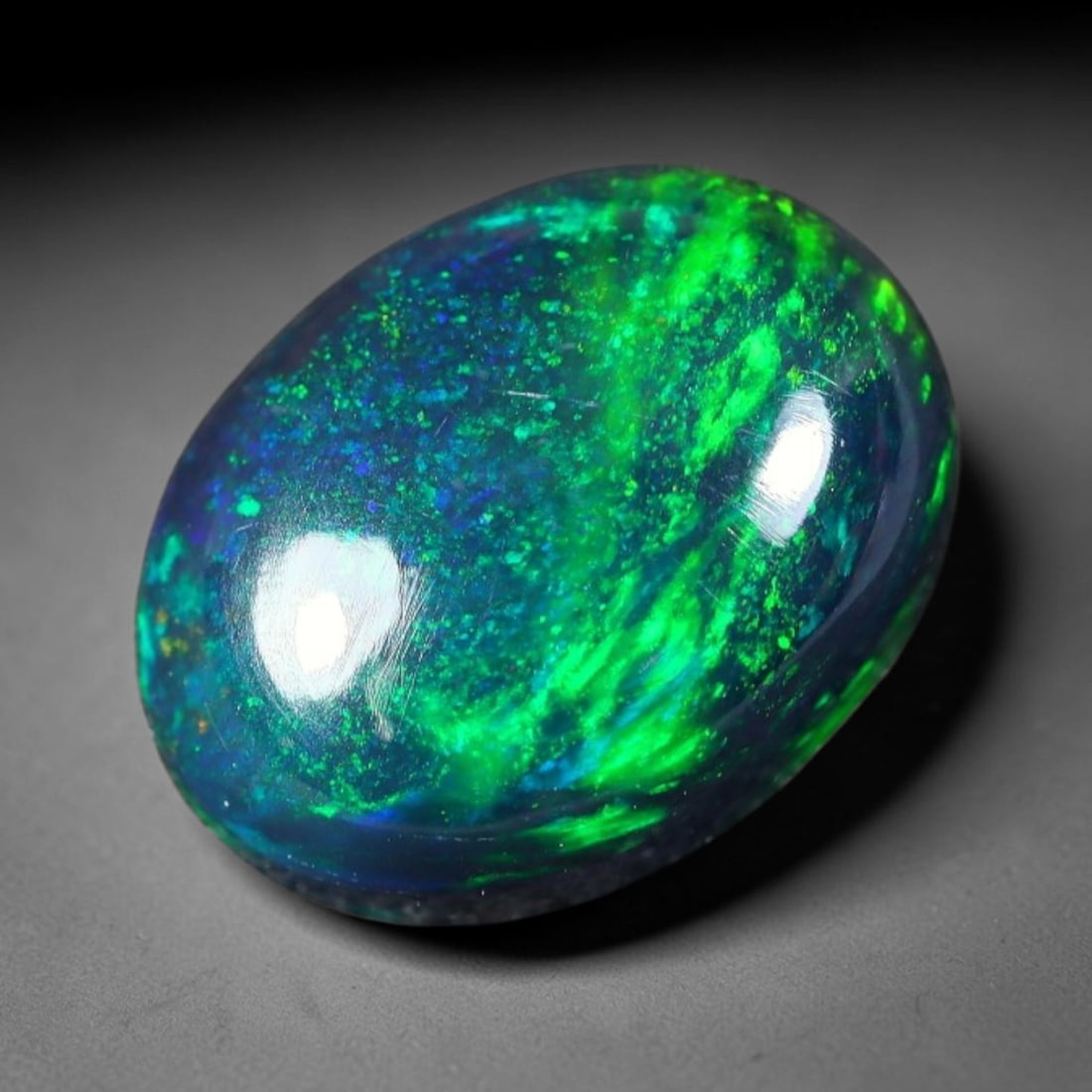 2.42ct Natural Ethiopian Welo Black Smoked Opal Cabochon Loose Gemstone, 58FX: This fully polished Ethiopian Welo opal features a dark smoked base with vivid, sweeping play-of-color shifting across its glossy dome surface, measured at 11x8x5mm. The black smoke treatment deepens 