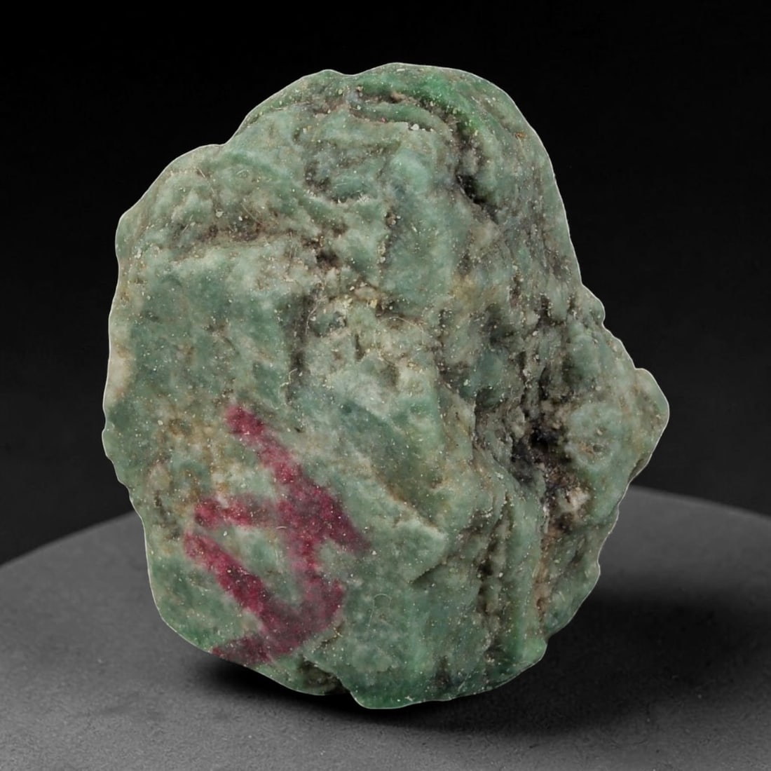 90Ct Natural Type A Burmese Jadeite Jade Rough Stone - Green Raw Material, 45EA: This is a natural, unpolished rough stone of Type A Burmese jadeite jade, weighing 90 carats and measuring 3x2.5cm. The stone displays a rich, muted green base with natural surface textures, dark mine