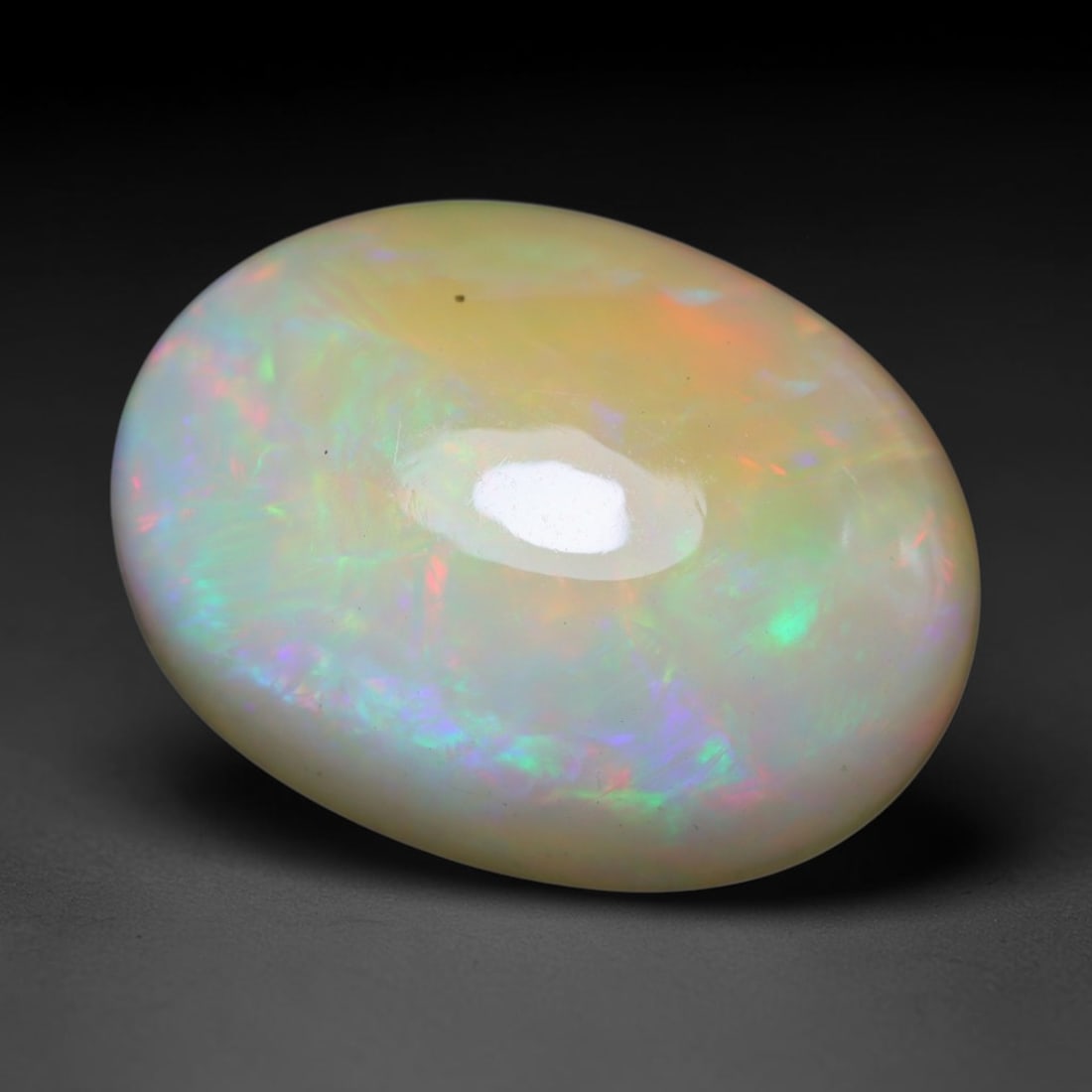 5.55ct Natural Ethiopian Welo Opal Cabochon Loose Gemstone, 30BY: This smoothly polished cabochon is genuine natural Ethiopian Welo opal. The translucent base hosts vivid multi-coloured play-of-colour, displaying dynamic flashes of multi color that shift as the view