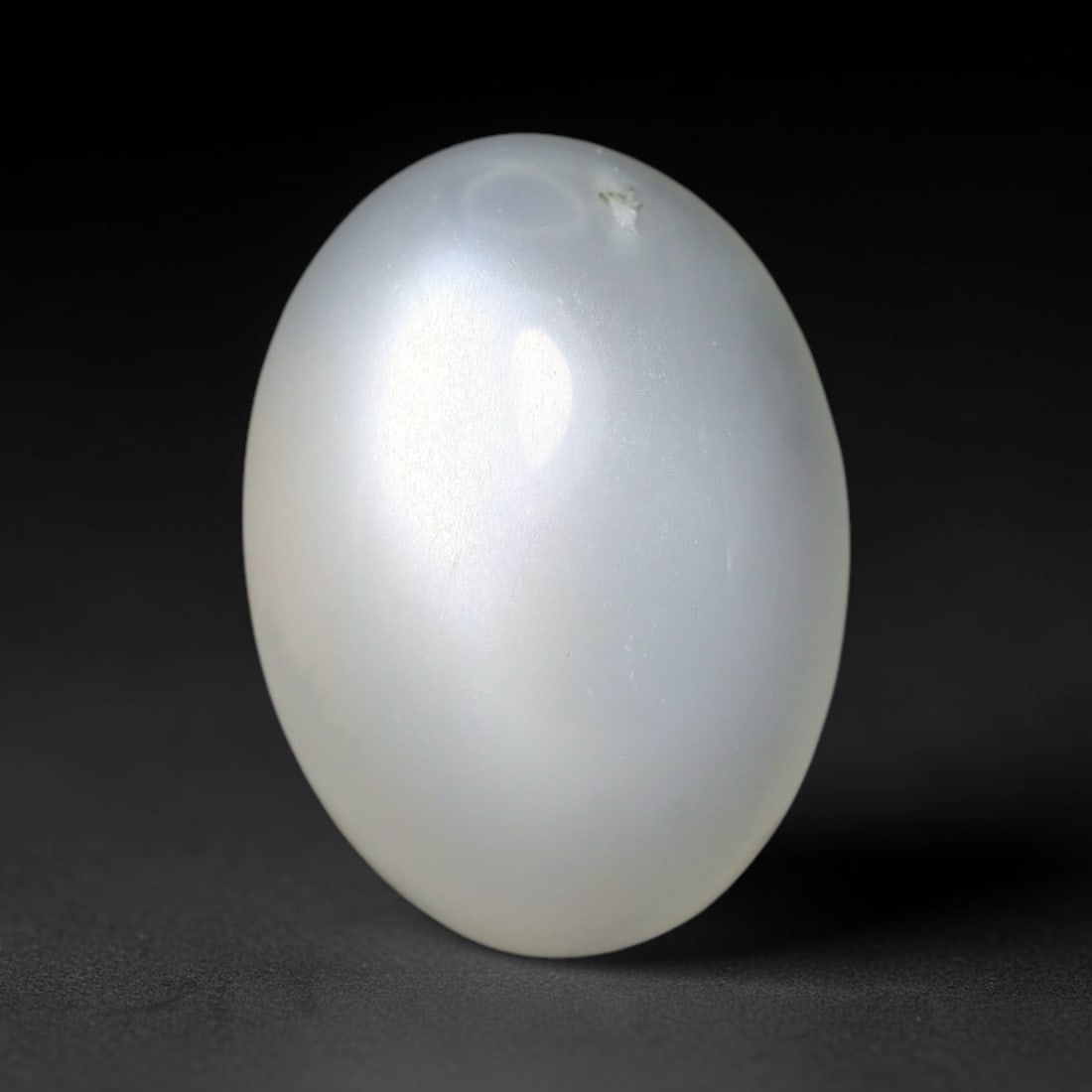 11.09ct Natural Ceylon White Moonstone Cabochon Loose Gemstone, 99FX: This natural Ceylon moonstone cabochon carries a milky white body showcasing classic adularescence. Fine mineral inclusions are visible within the gem. Dimensions measure 15x11x8mm, mined in Sri Lanka
