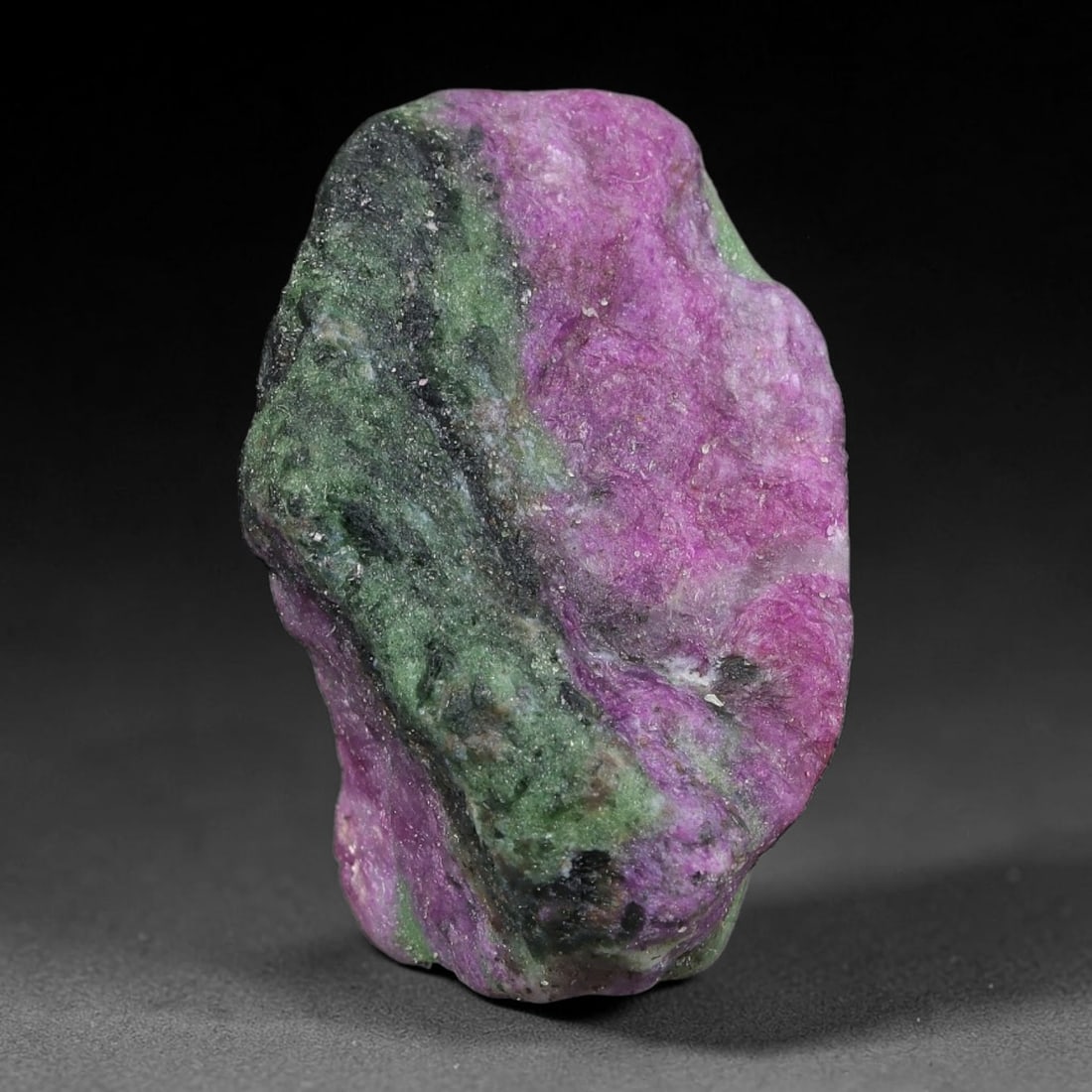 75ct Natural Tanzanian Ruby Zoisite Raw Rough Specimen Mineral Stone, 14FC: This unpolished mineral rough is natural ruby zoisite sourced from Tanzania, exhibiting distinct banded mineral segregation of vibrant green zoisite, magenta ruby crystals, and dark hornblende inclusi
